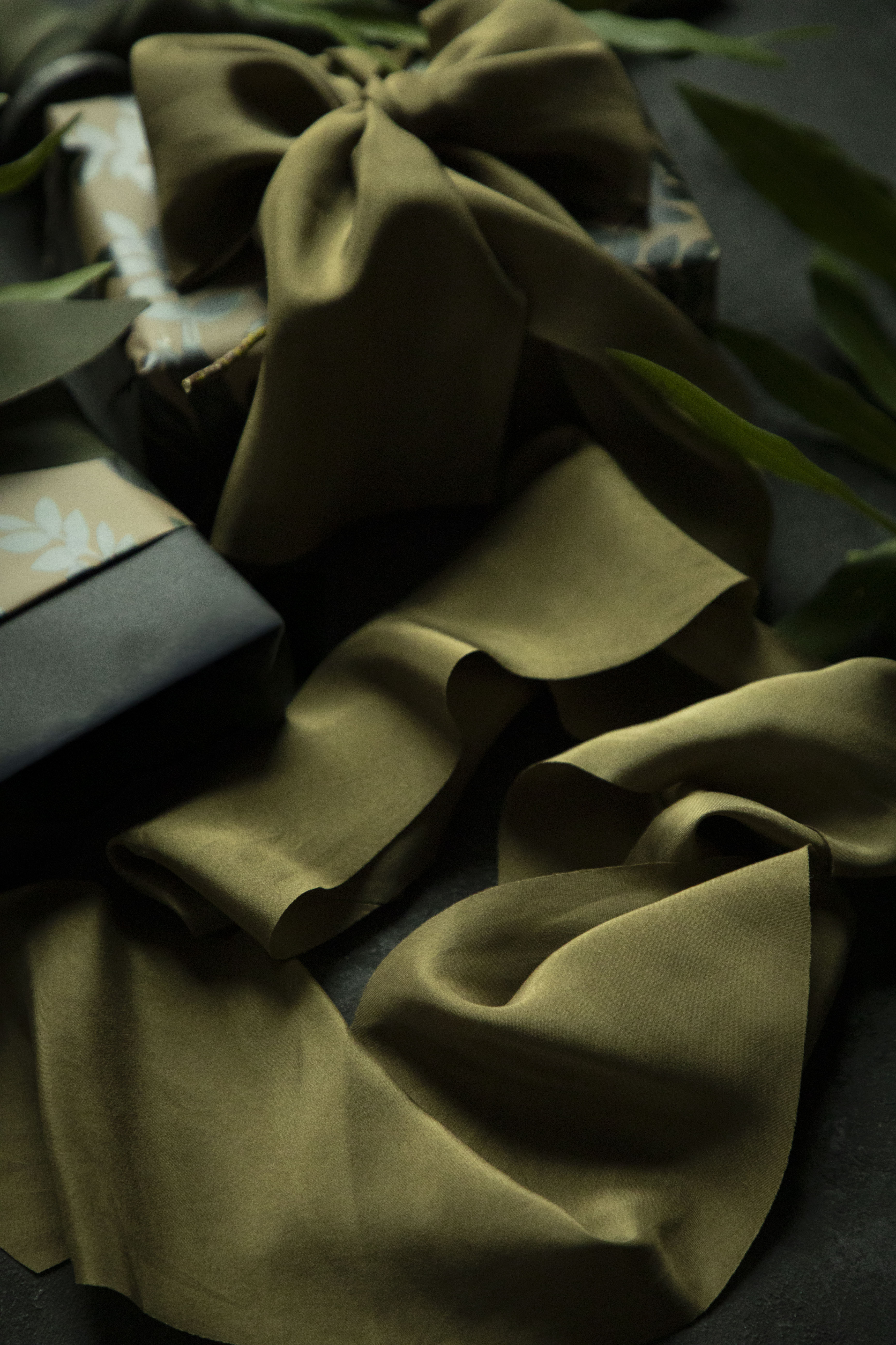 Green fabric with a bow on a gift and on a dark background