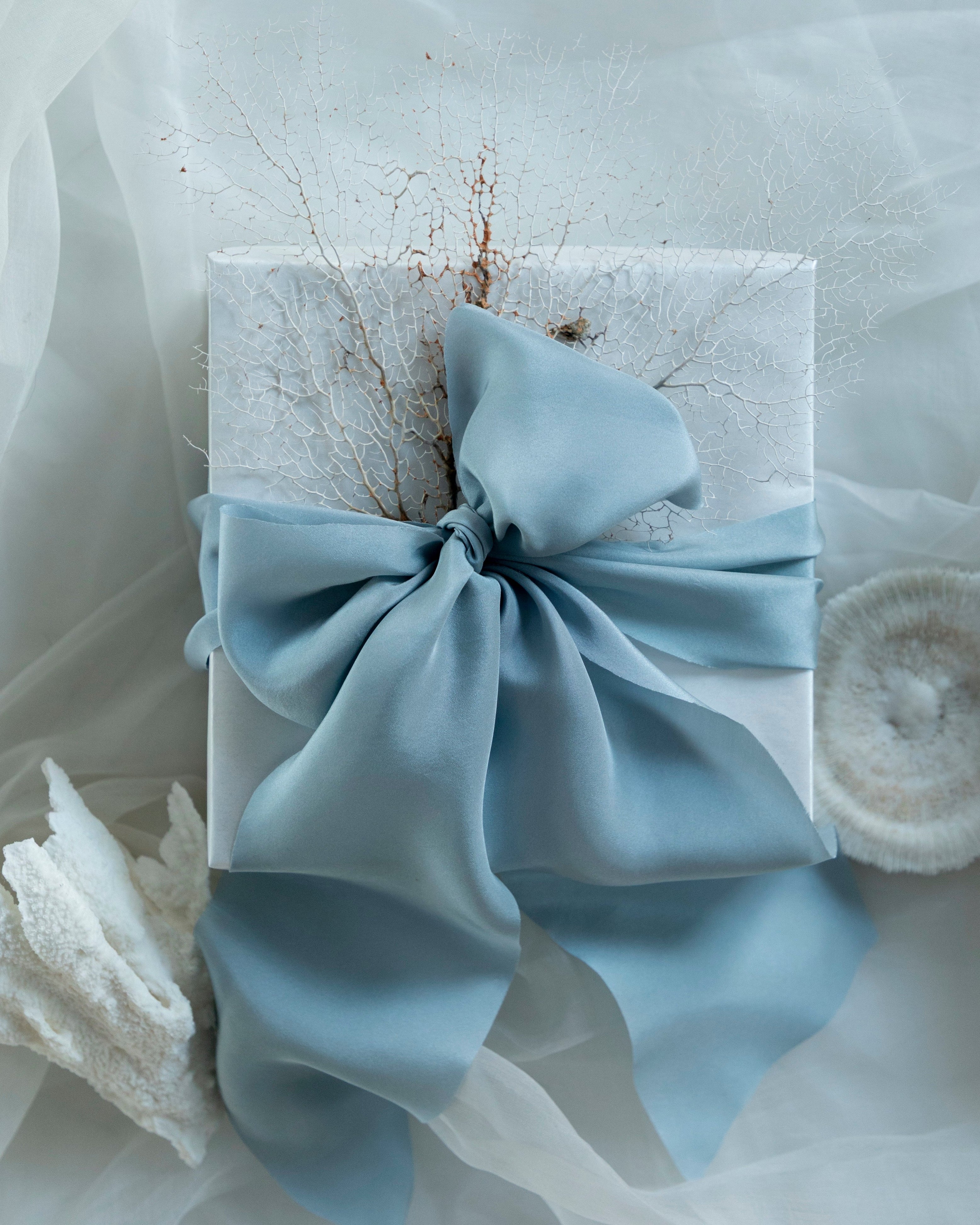 French blue bow on a white box with a white background. luxury giftwrapping