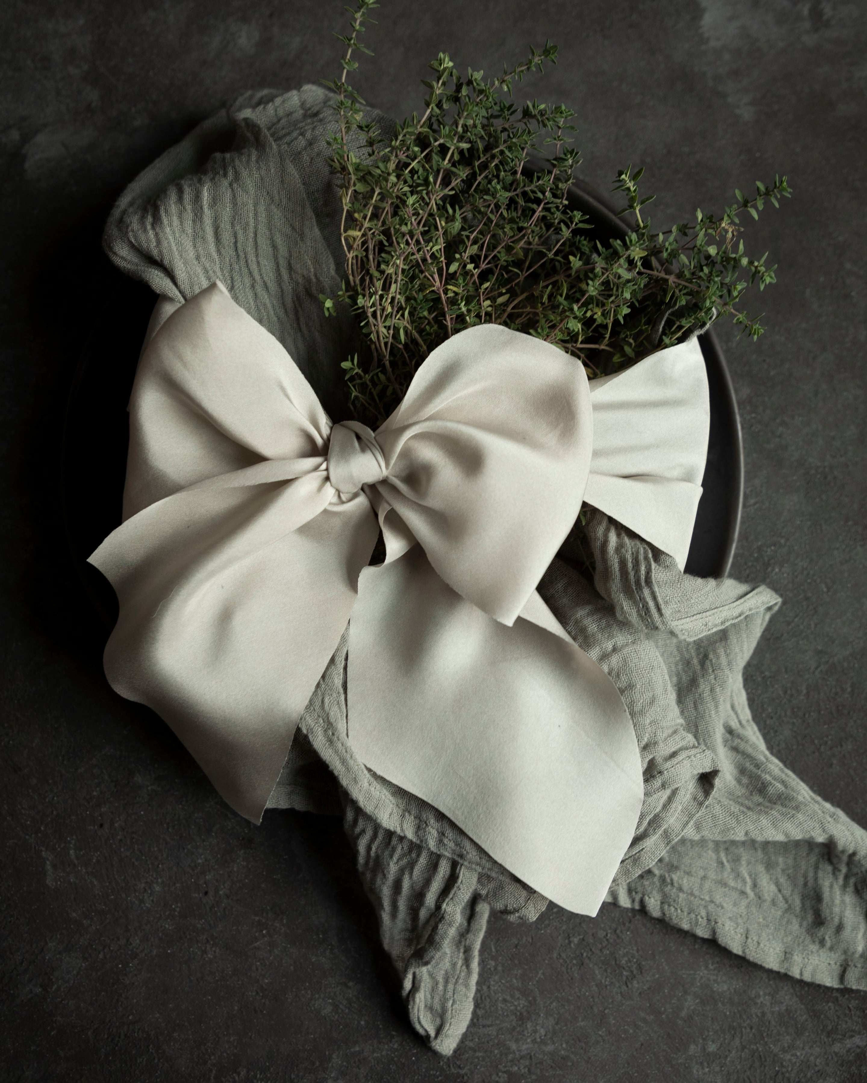 Floral arrangement with a large bow on a dark background