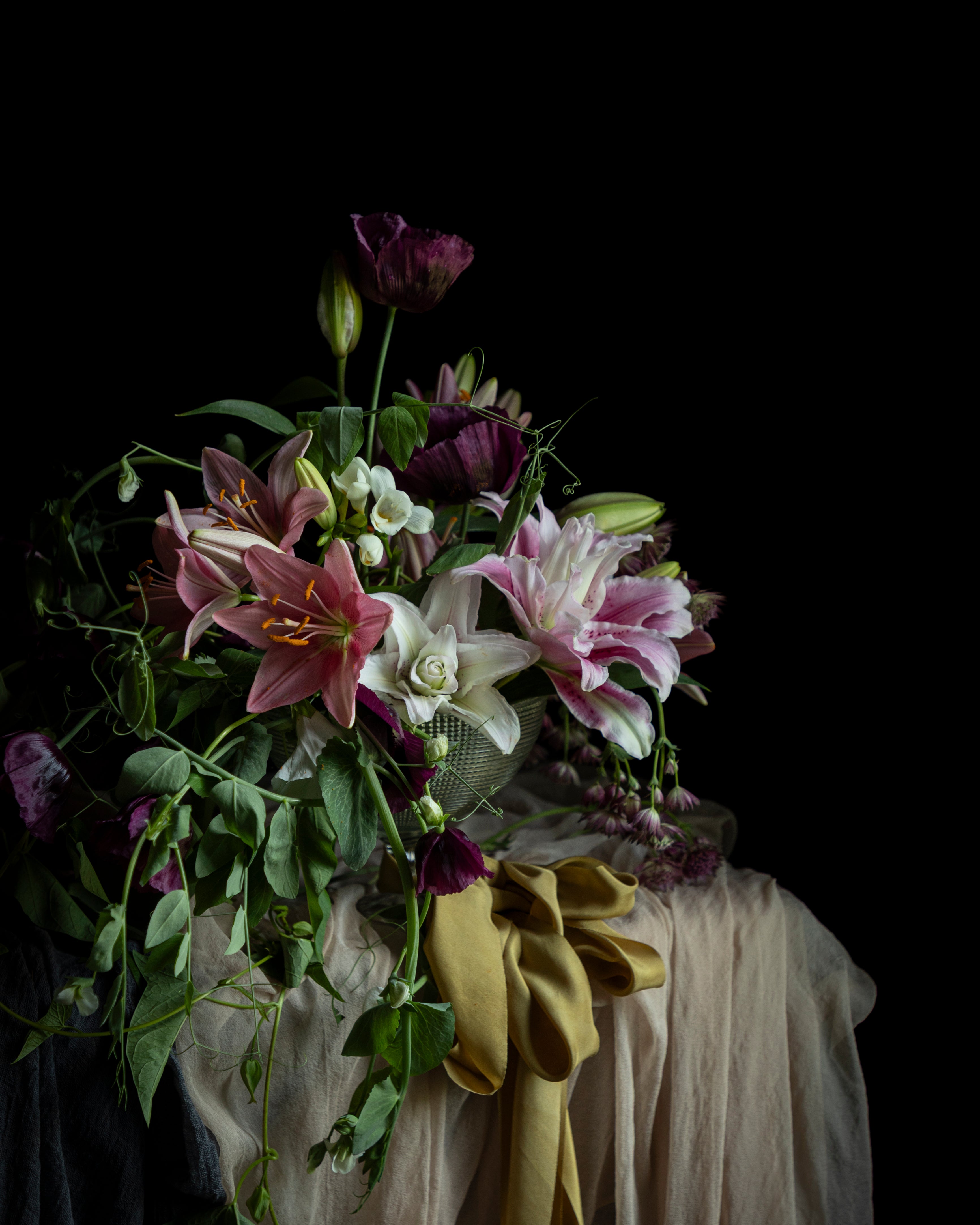 Floral arrangement with a green ribbon on a dark background