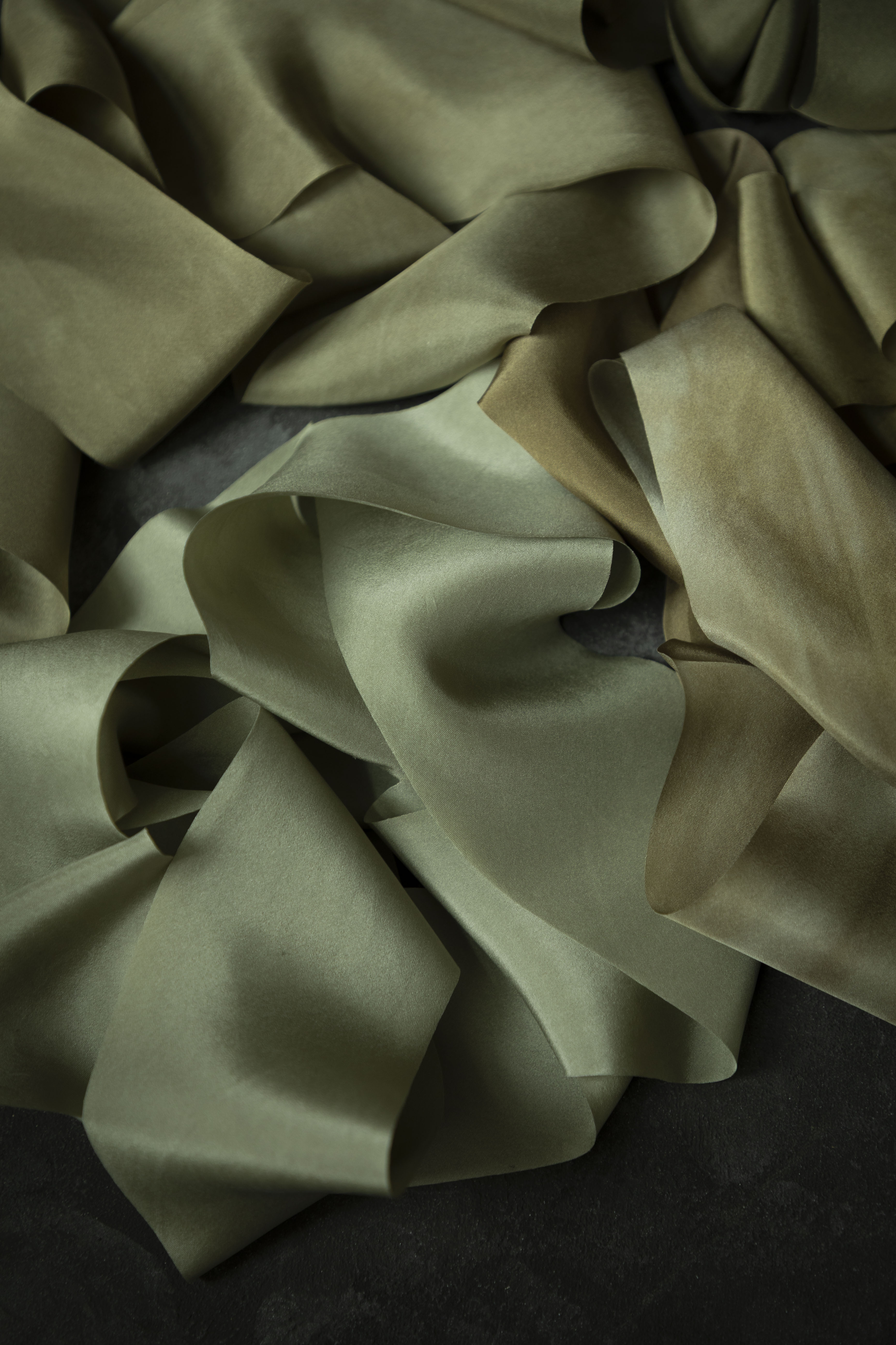 Close-up of green silk ribbon on a dark background