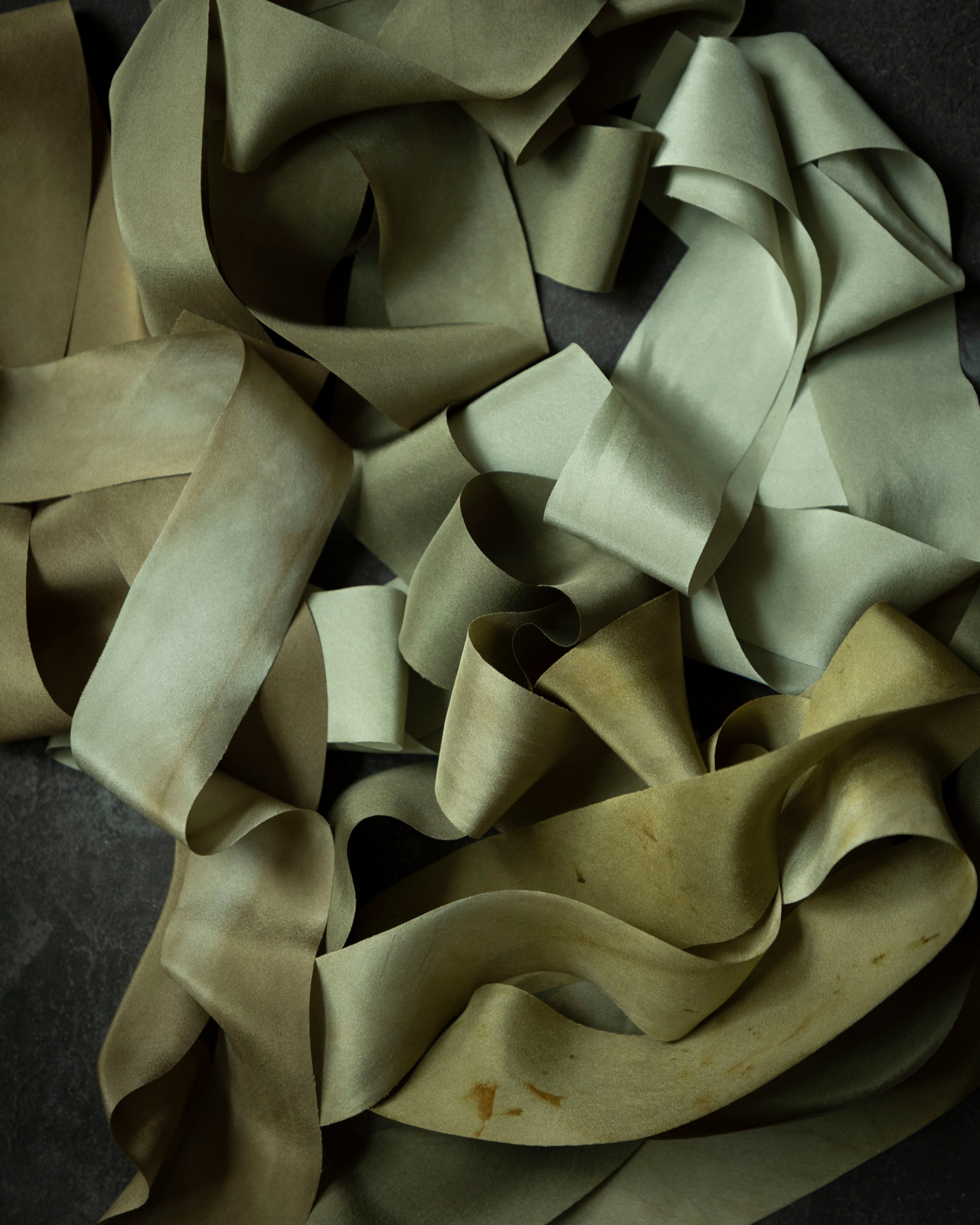 pile of premium green silk ribbon on a dark background