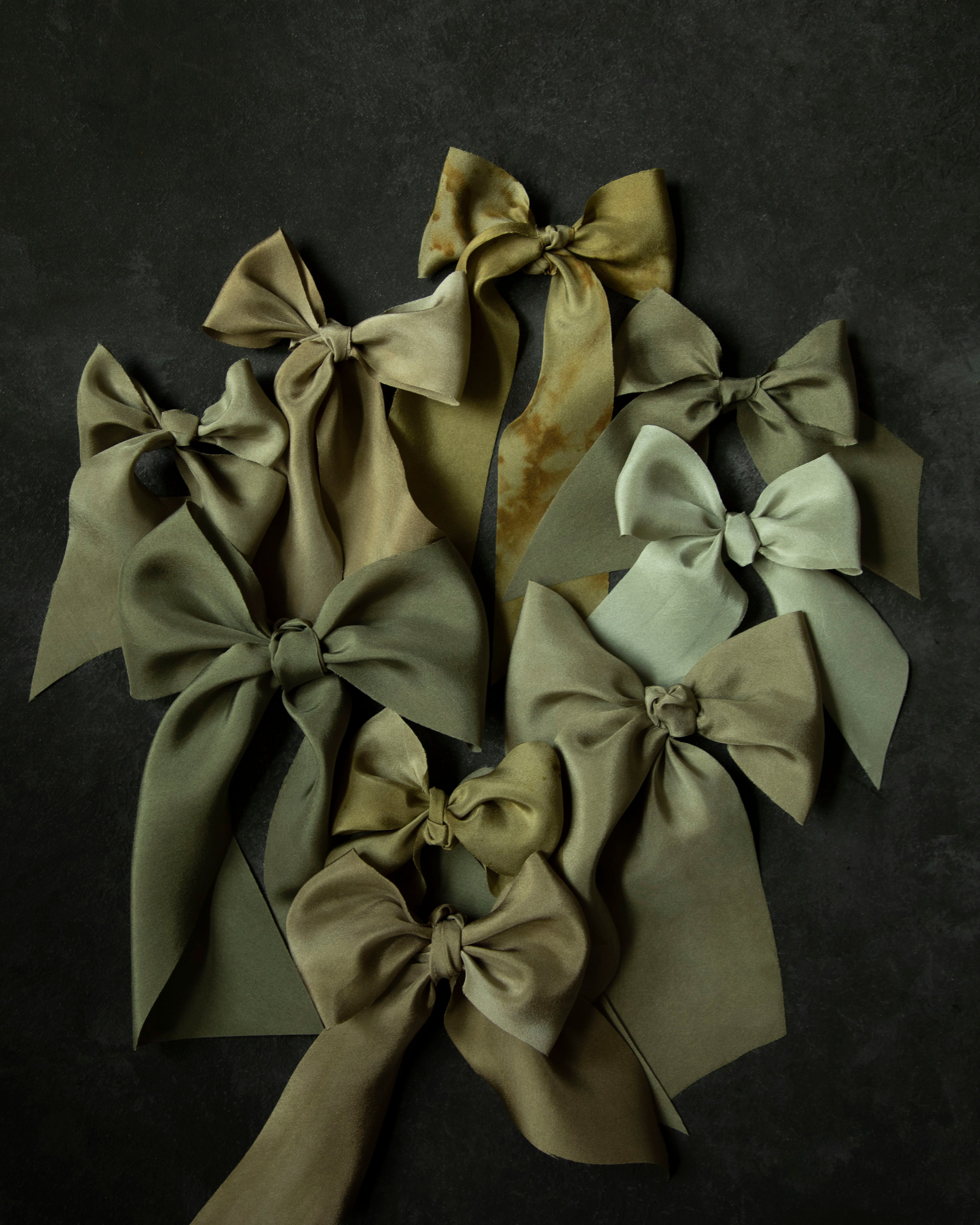 Set of green and beige hair bows on a dark background