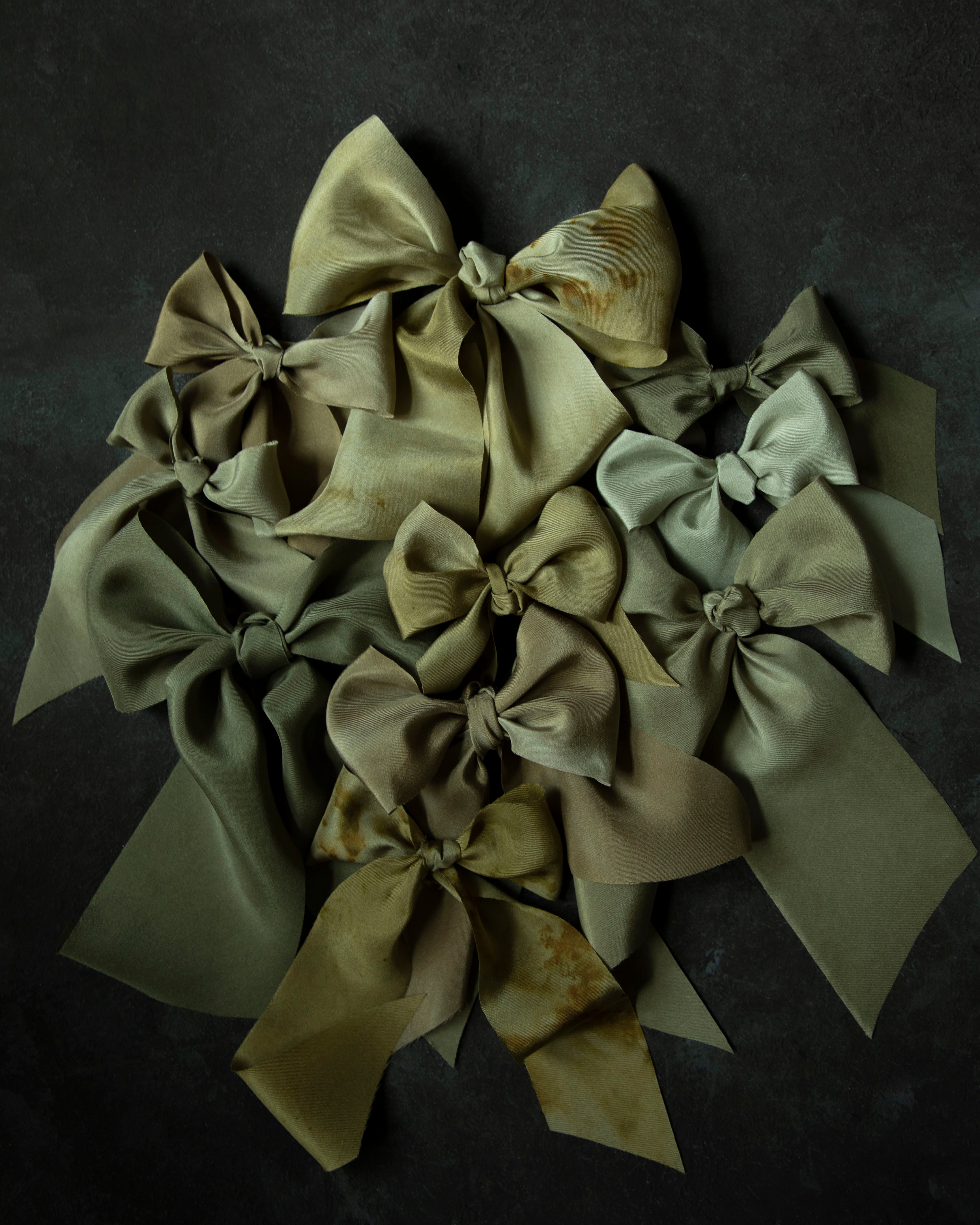 Collection of green silk ribbon bows on a dark background