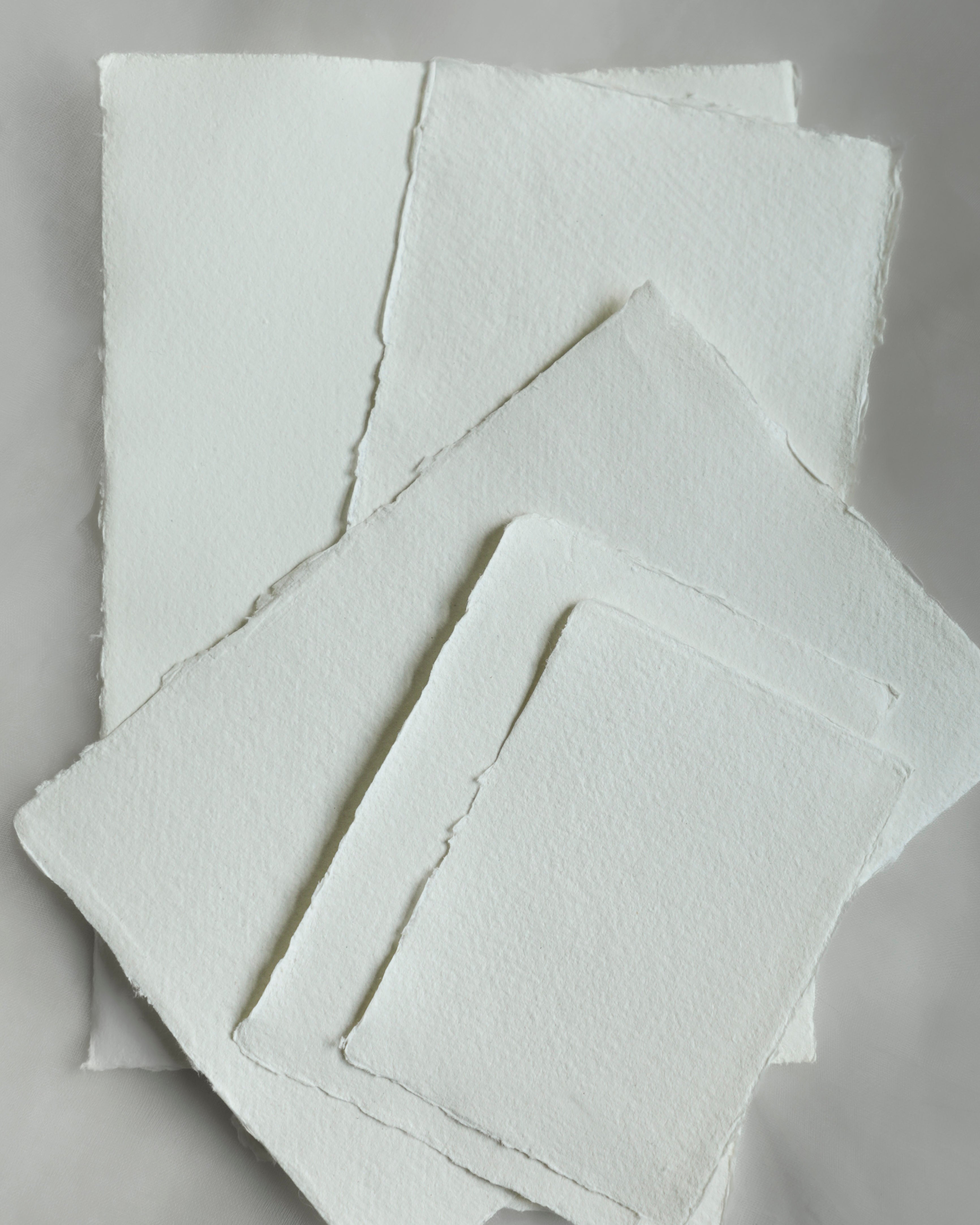 Stack of white textured paper sheets on a gray background