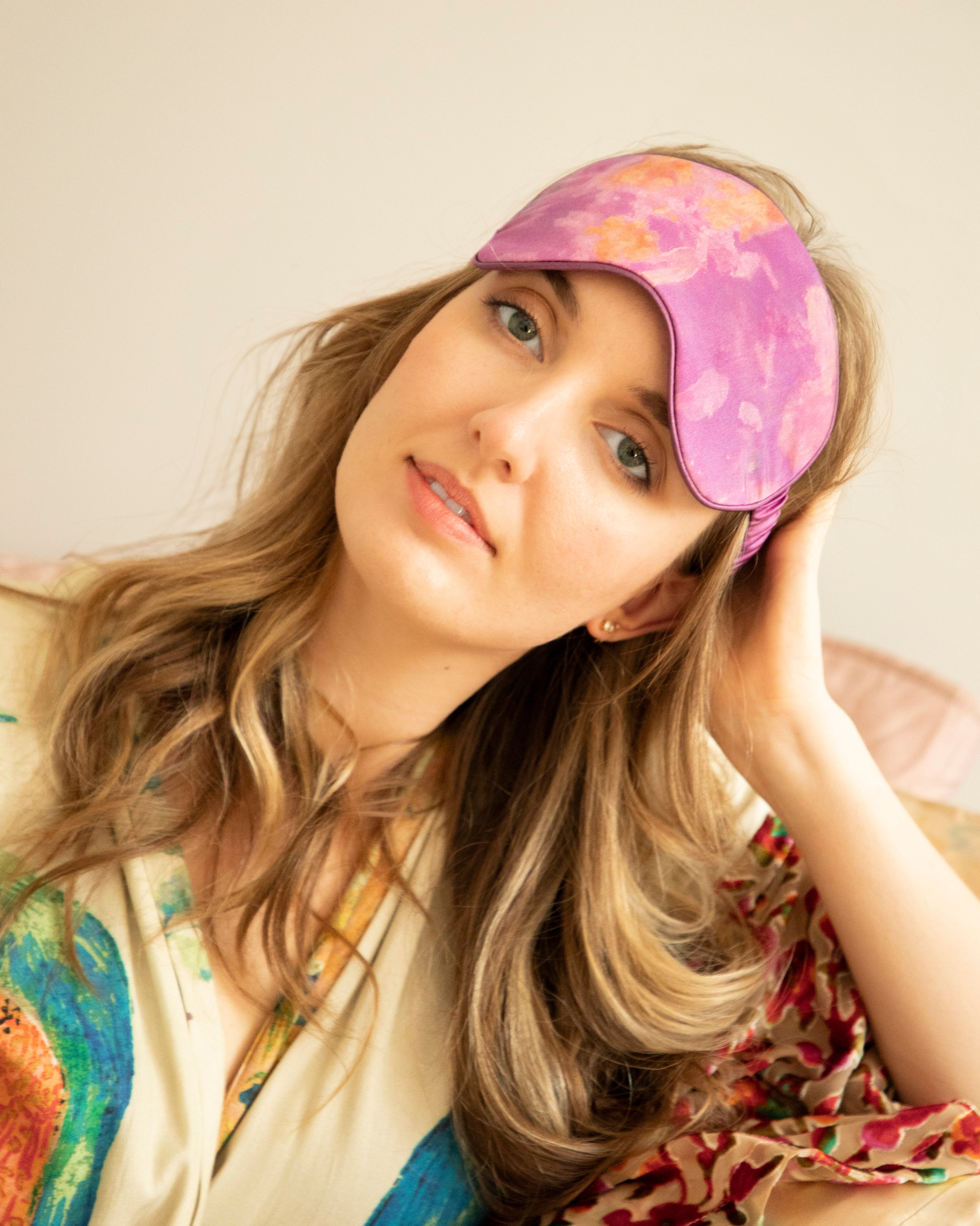 A model wearing a luxurious silk sleep mask adorned with delicate, nature-inspired botanical patterns. The mask exudes a fresh and restorative feel, combining elegance and comfort—a perfect addition to the Anthropologie aesthetic.
