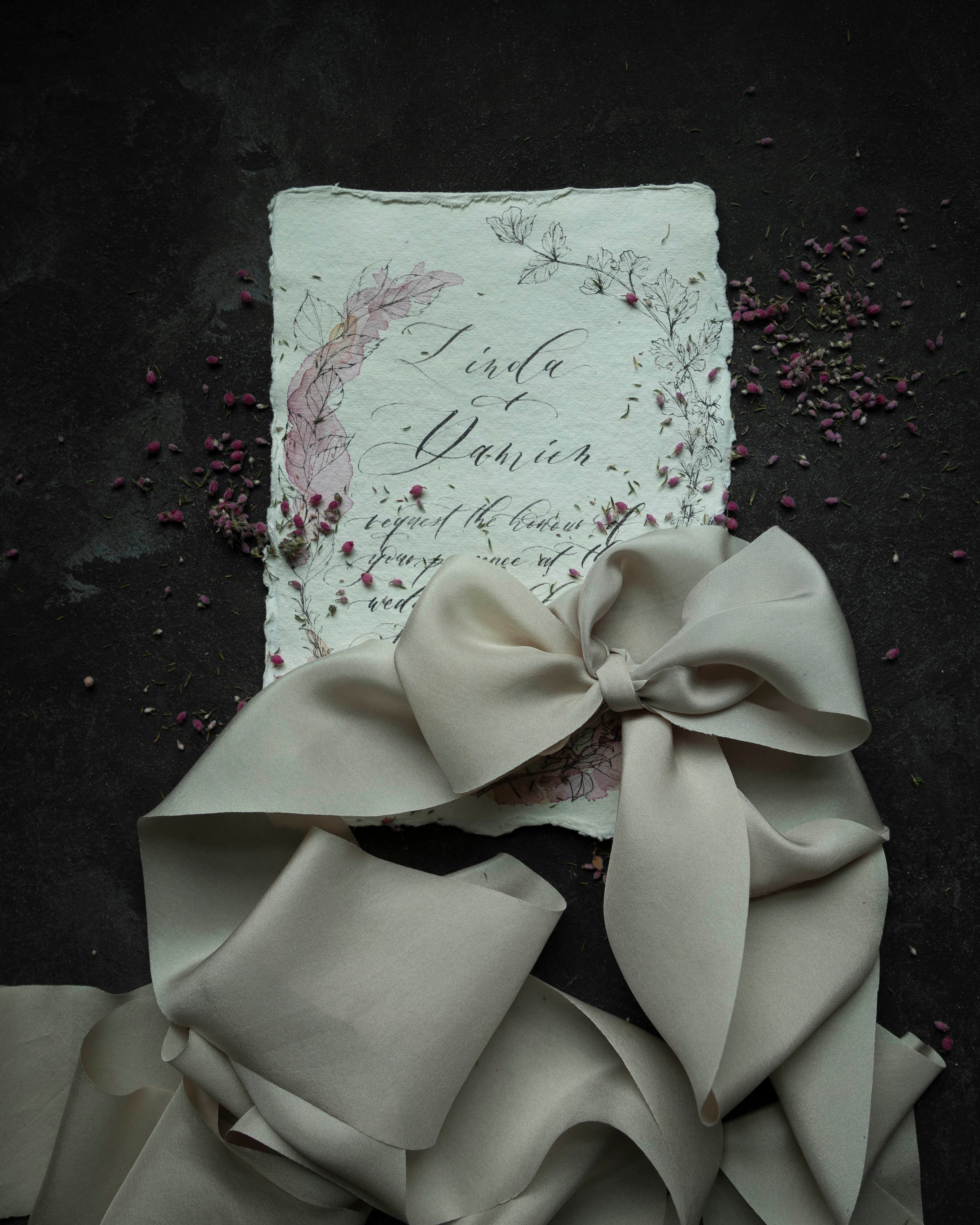 custom wedding invitation tied with a silk ribbon bow