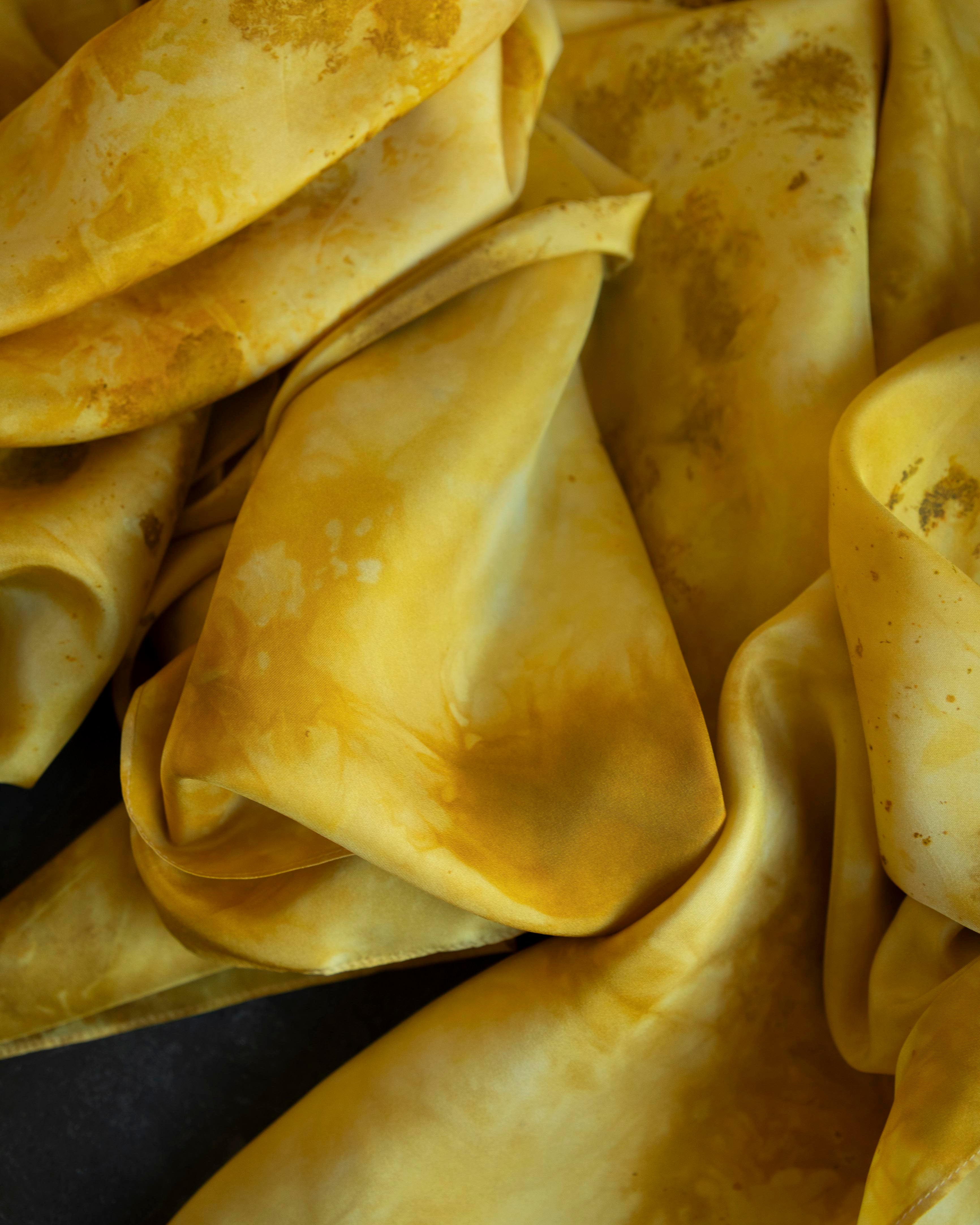 Close-up of yellow fabric with visible stains and discoloration