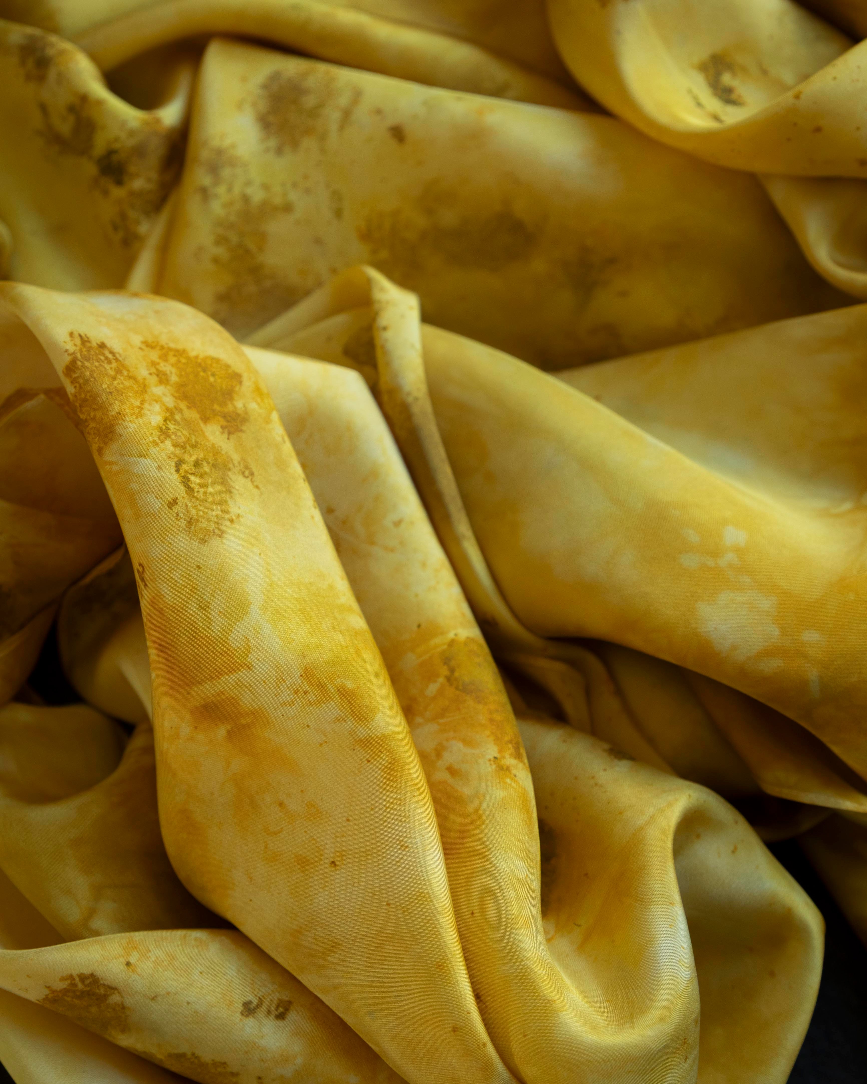 Yellow fabric with brown stains and discolorations