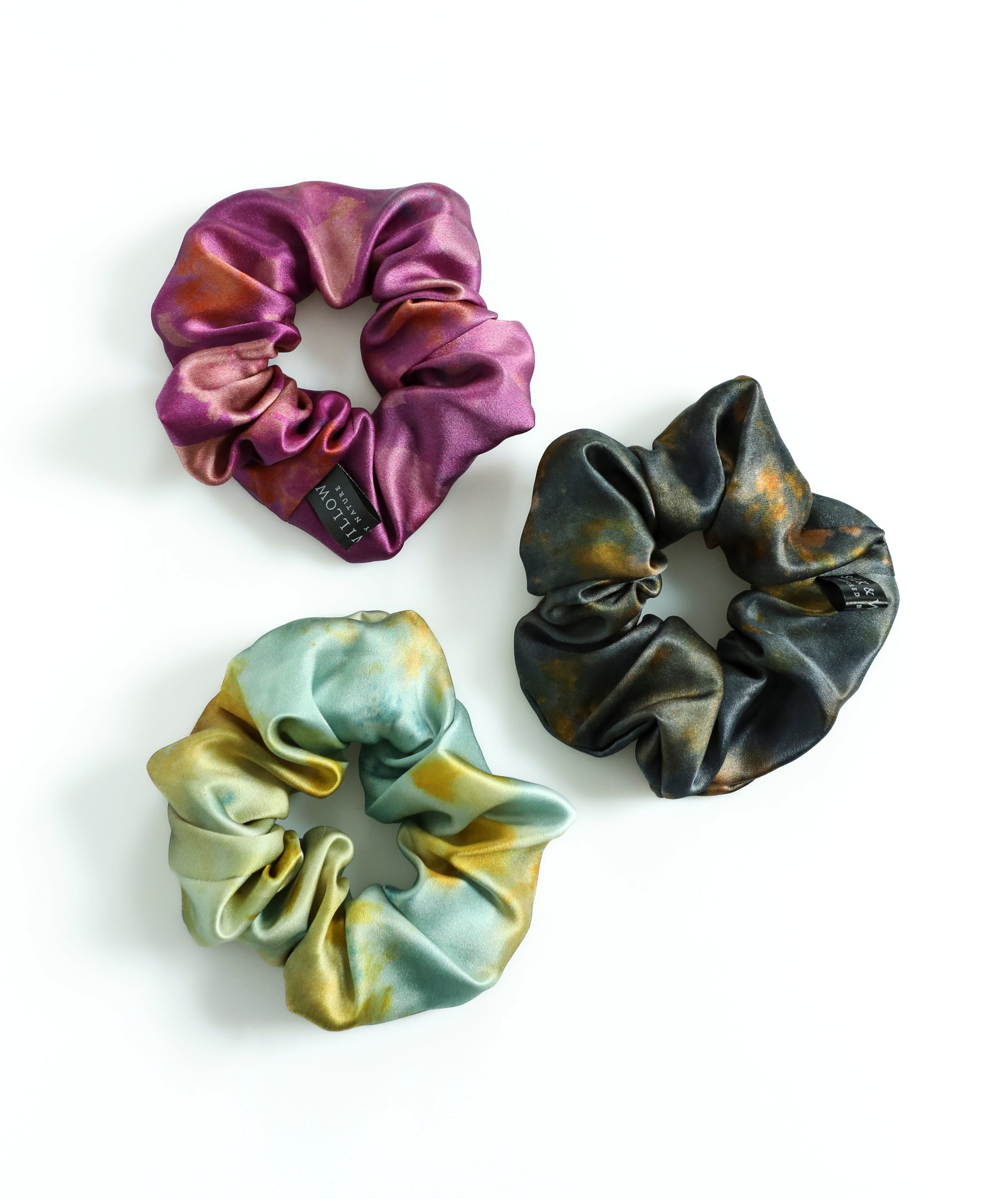 Three colorful scrunchies on a white background