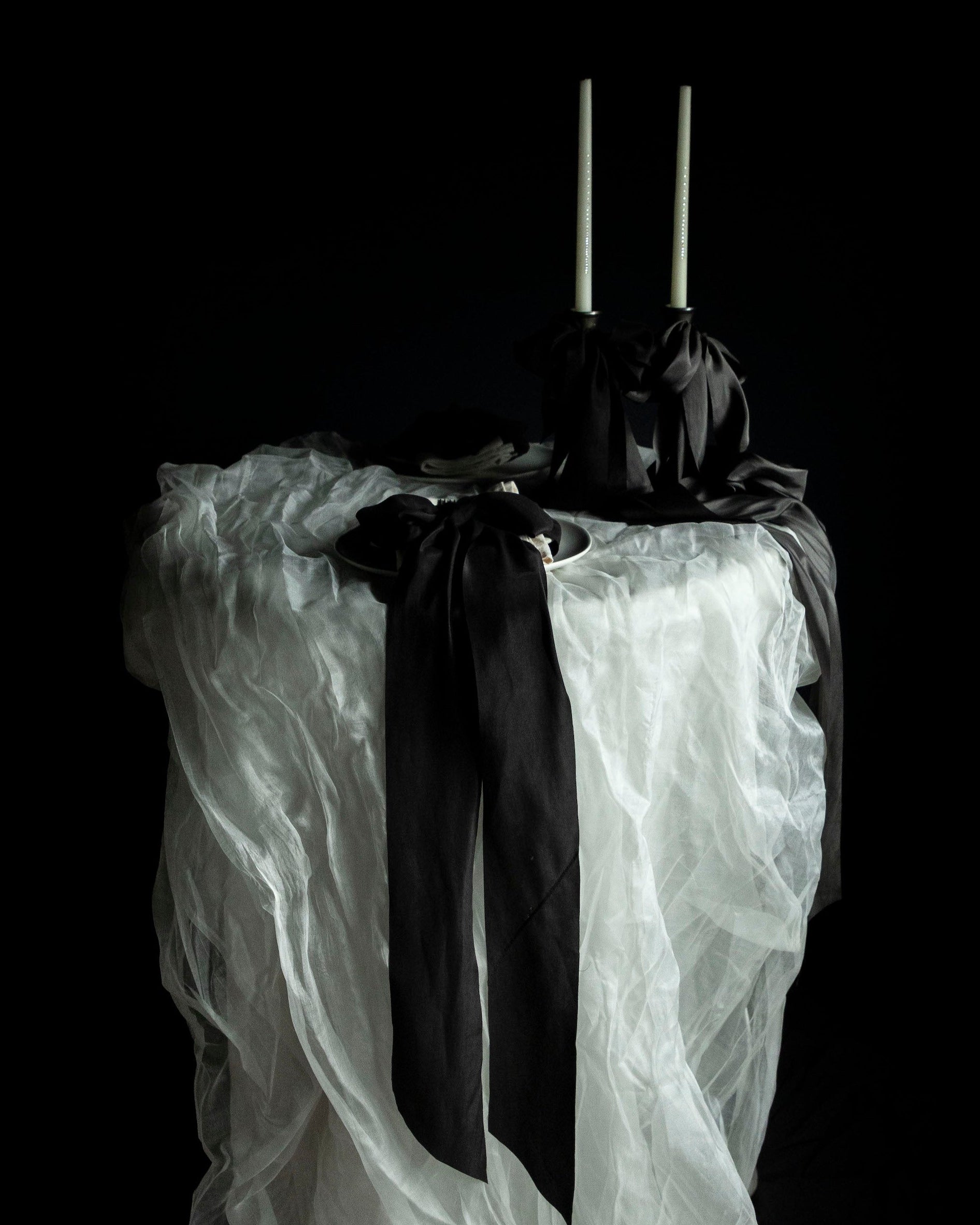 tablescape design. Wedding table with flowing white silk and black bow details