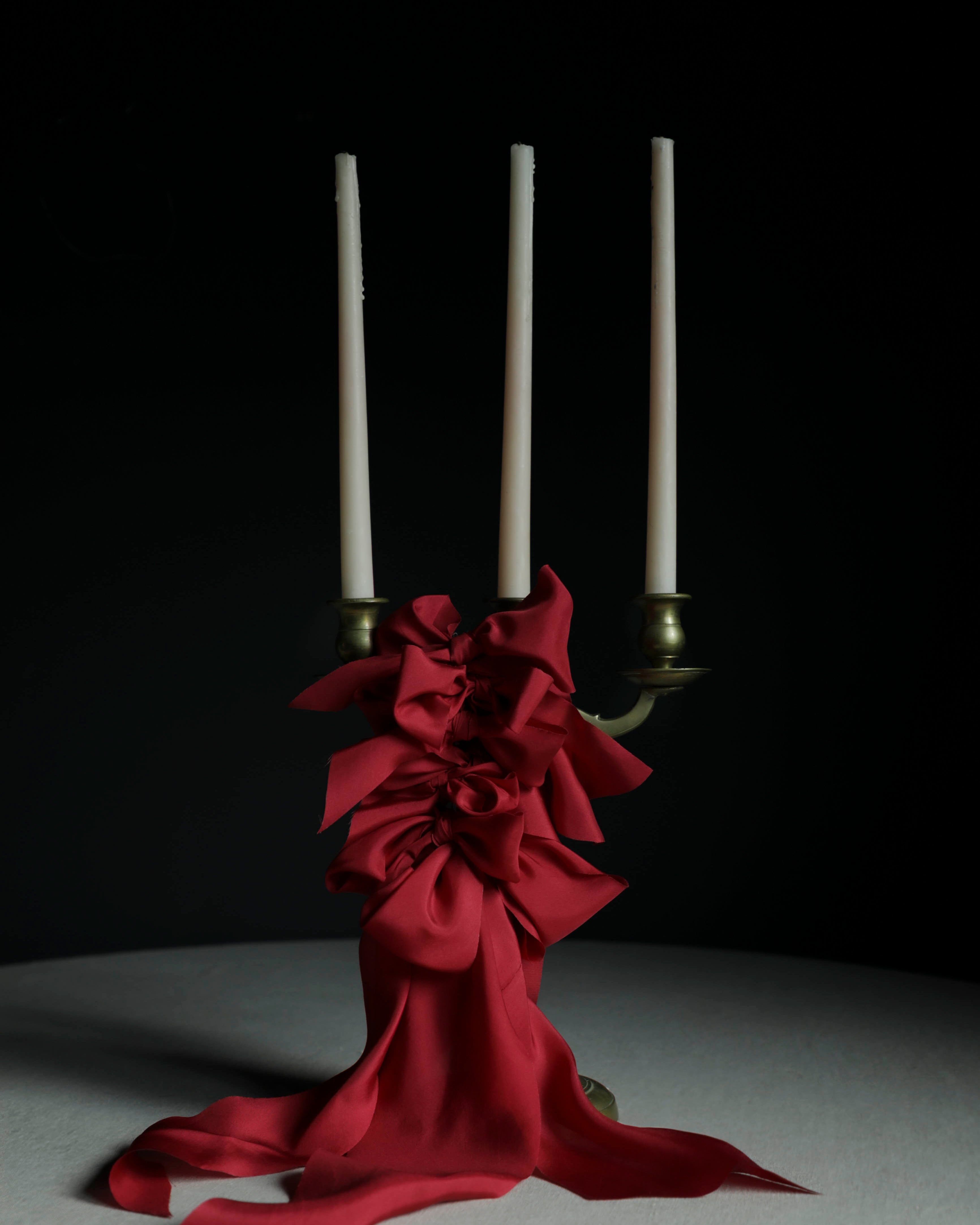 Cherry red silk ribbon bows on candles