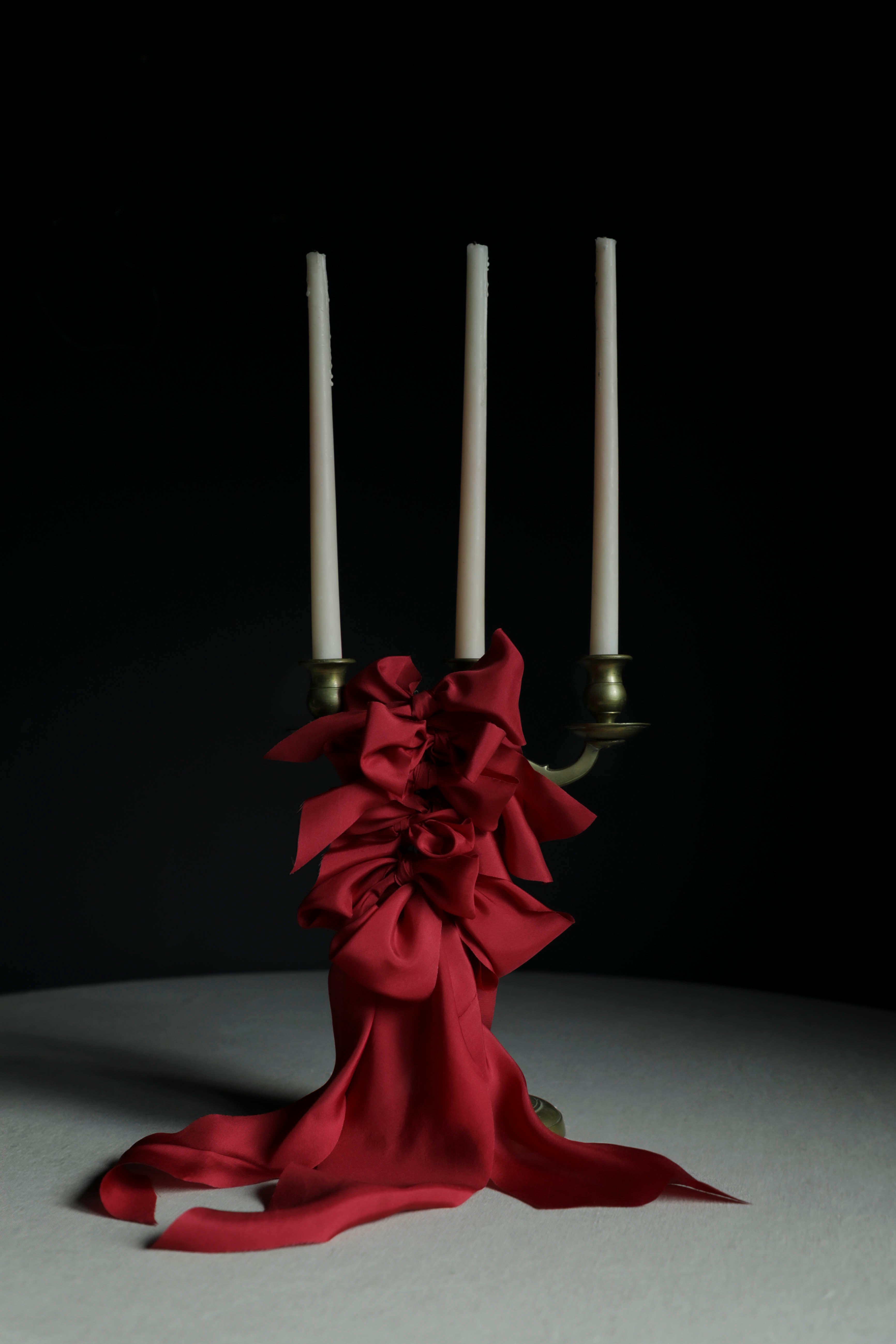 Cherry red silk ribbon bows on candles