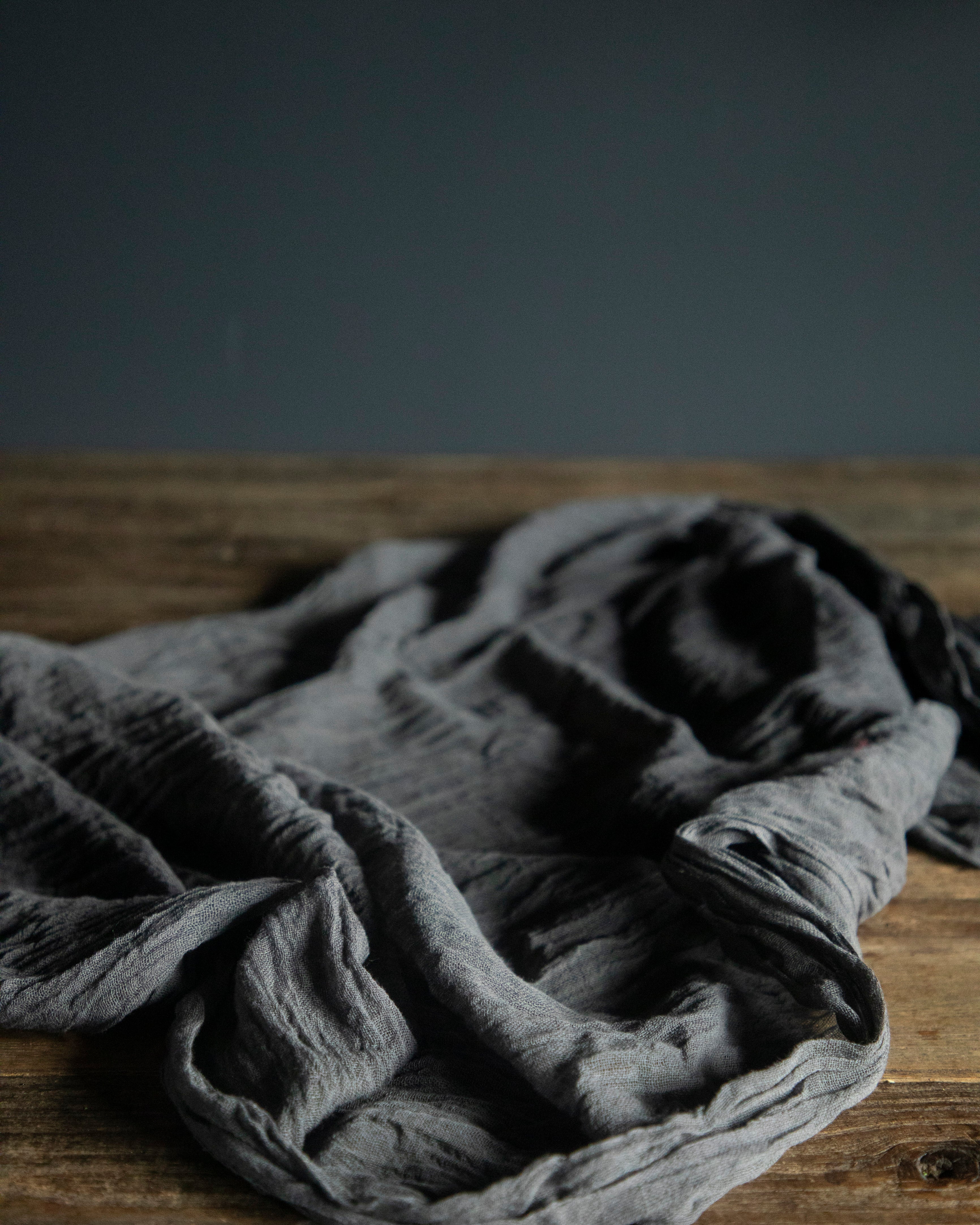 Gray fabric on a wooden surface with a dark background