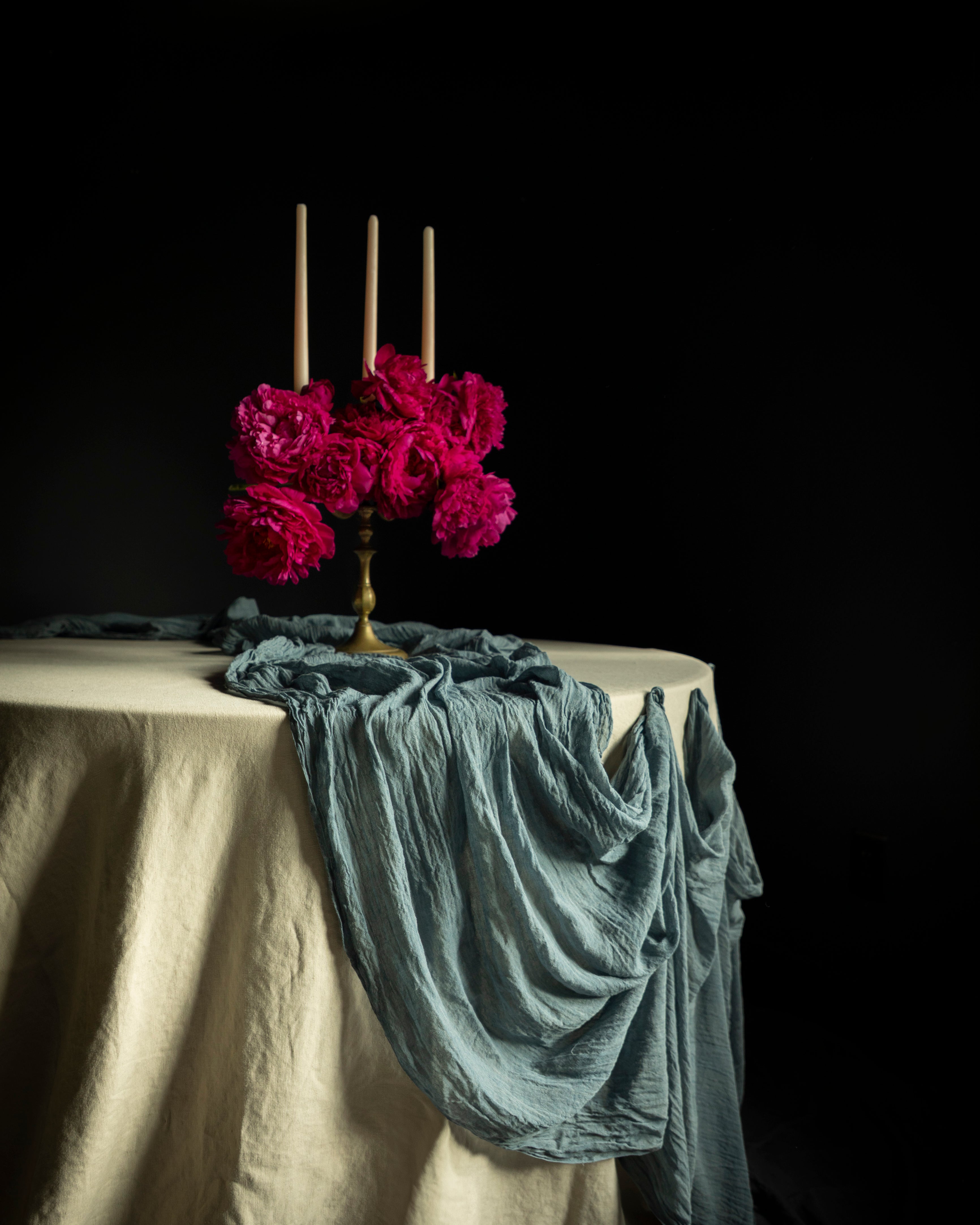 Table setting with pink flowers and candles on a dark background