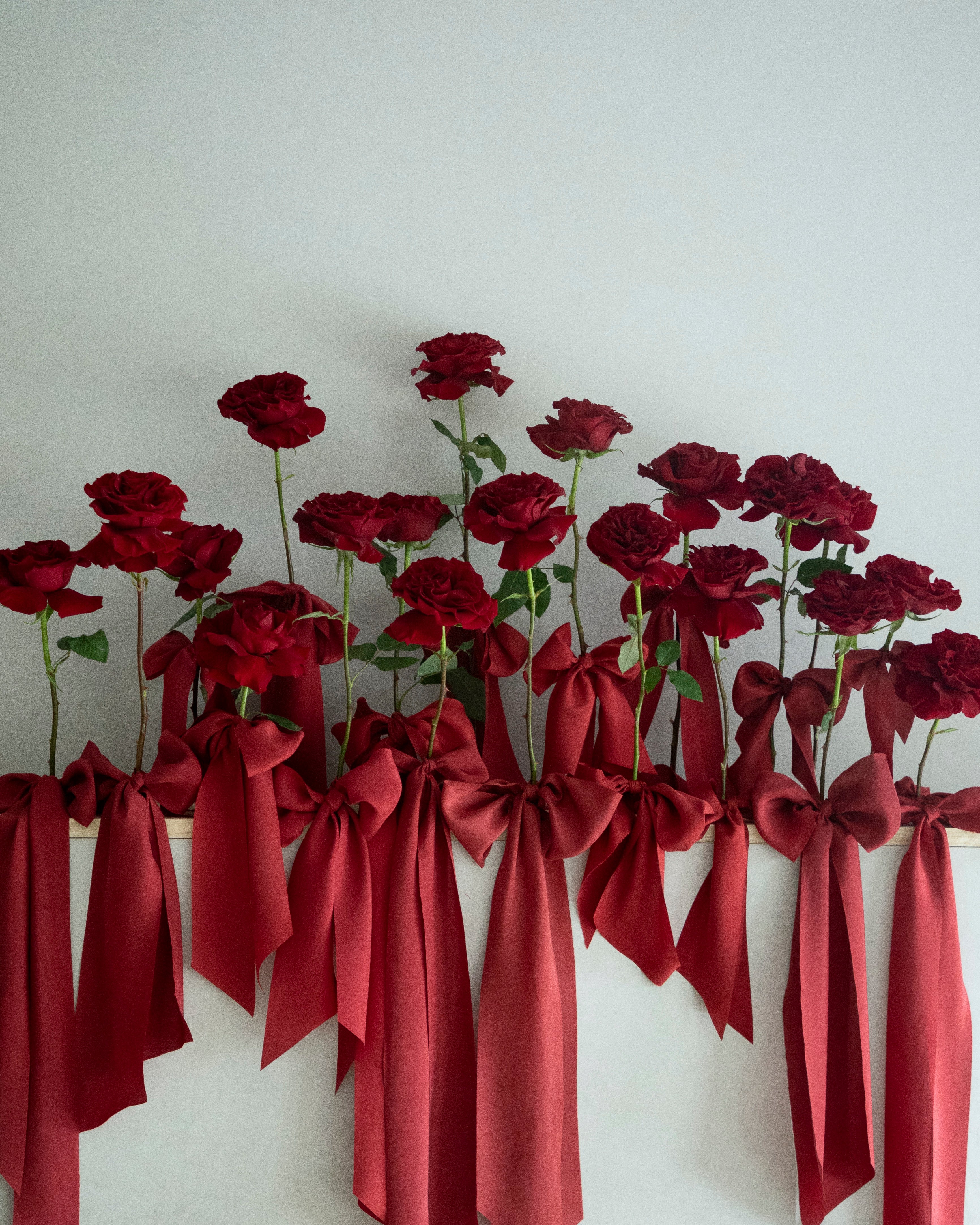 red wedding trend. red roses on display with red silk ribbon bows.