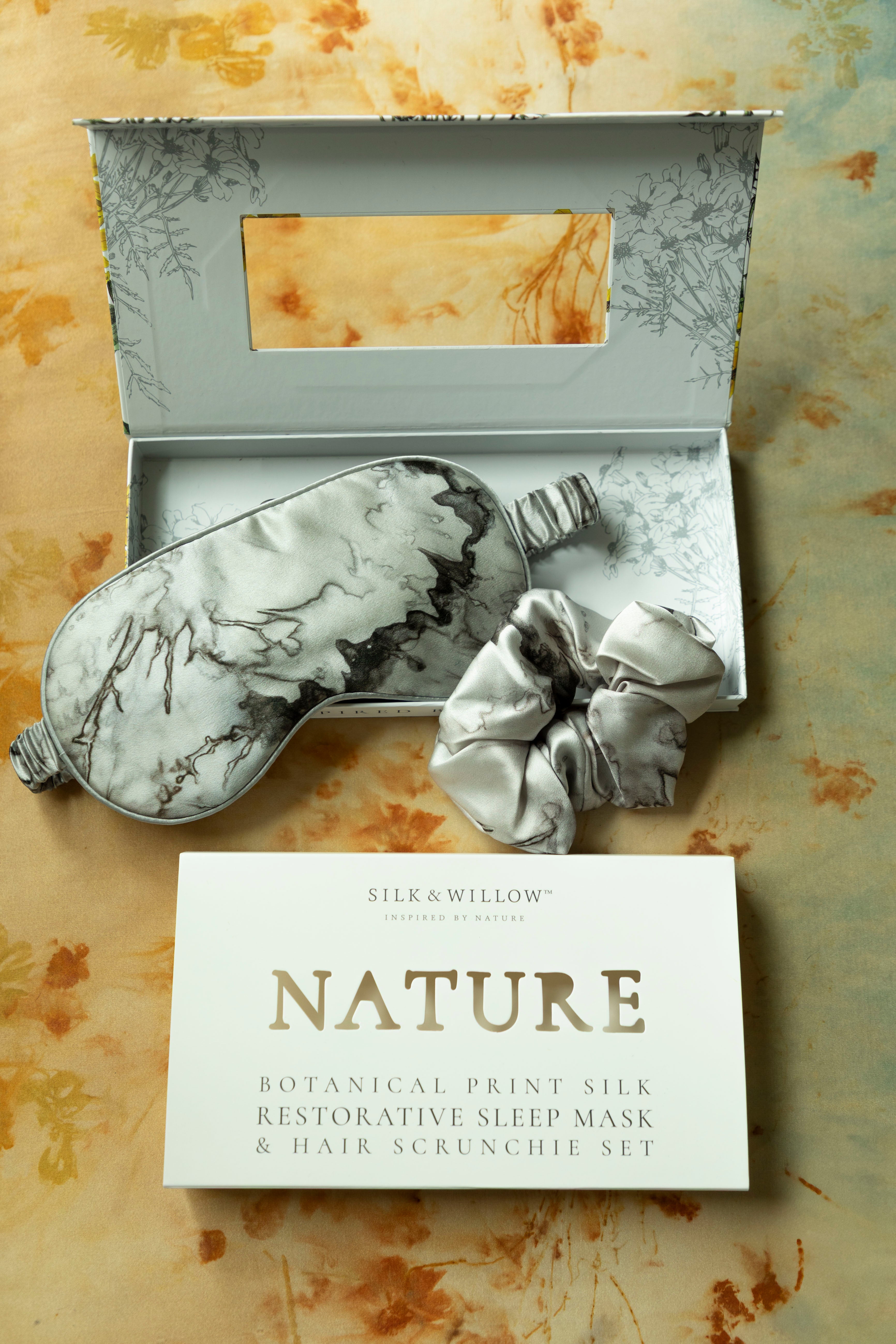 Silk sleep mask and hair scrunchie set with 'NATURE' card on a textured background
