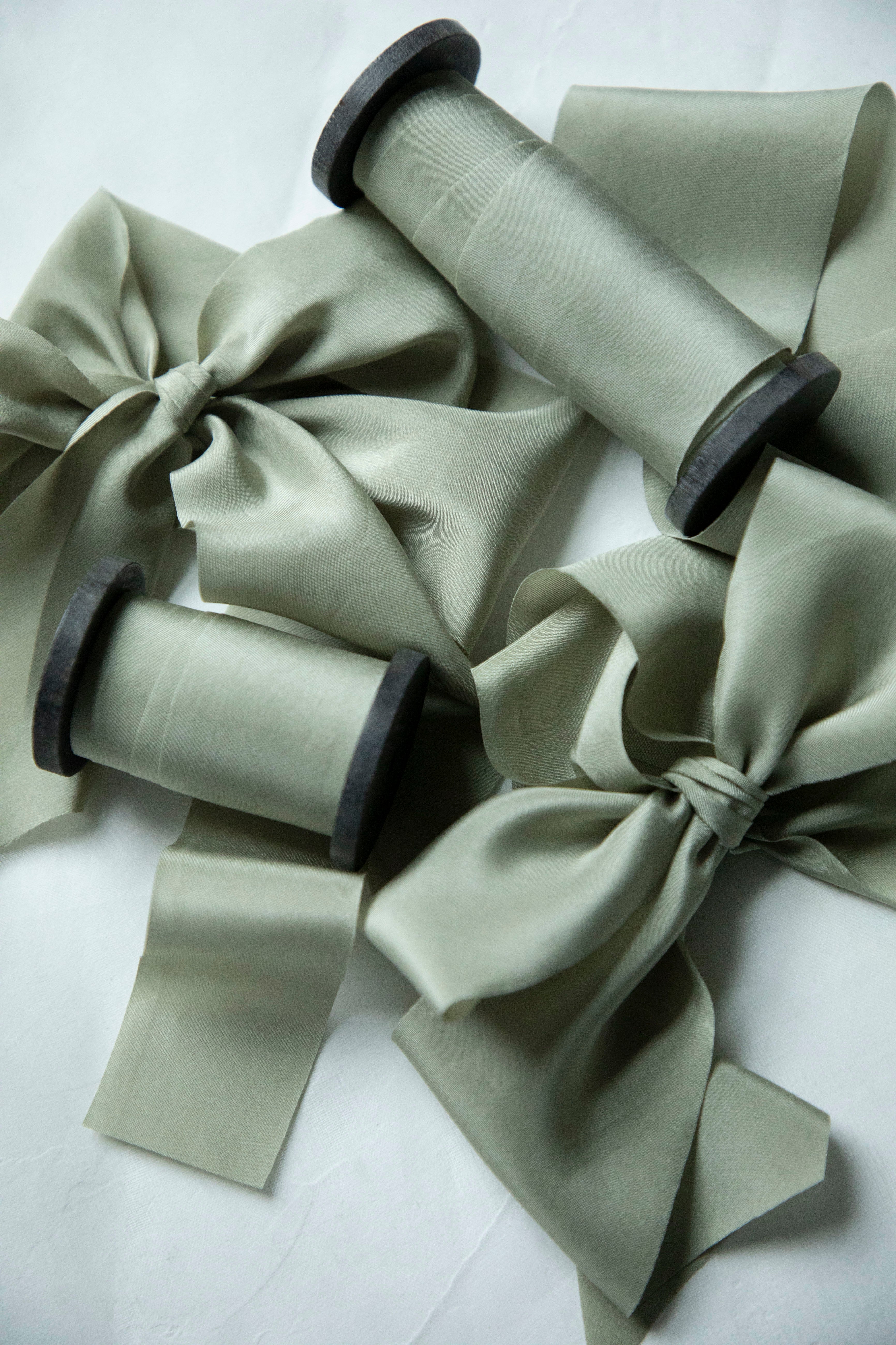 Spools of green ribbon with bows on a white background