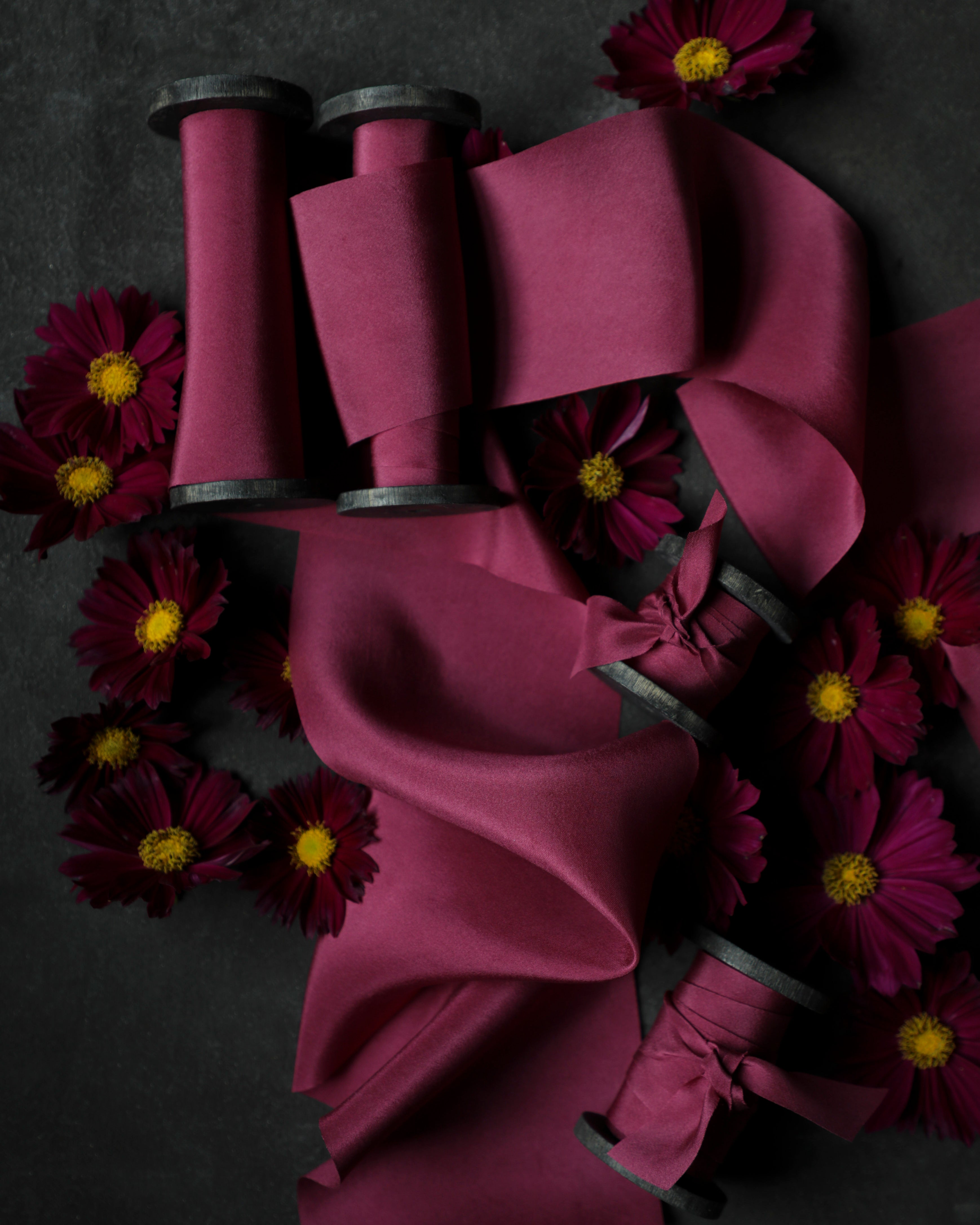 Purple ribbons on spools with purple flowers on a dark background