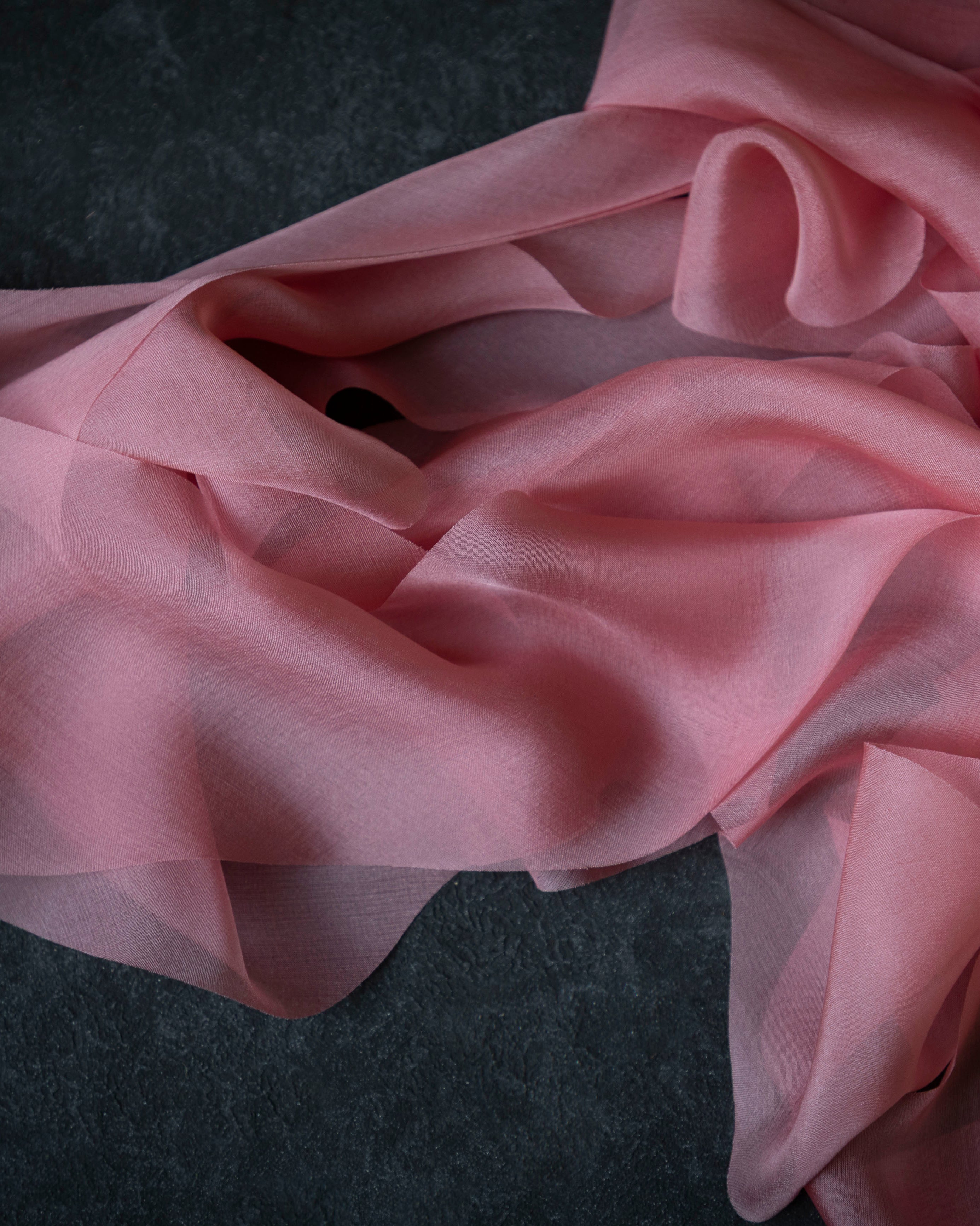 Pink silk ribbon fabric on a dark background
