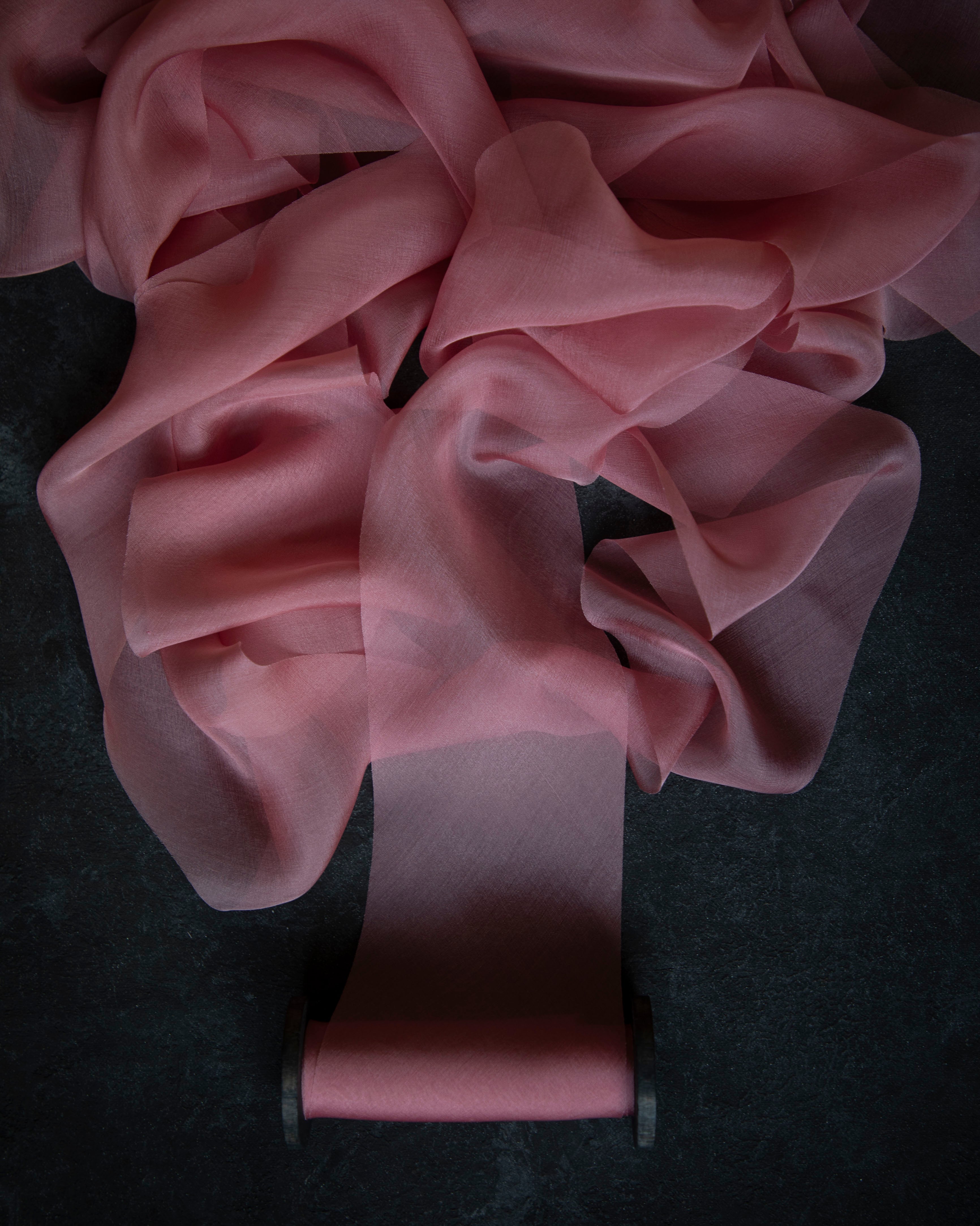 Pink silk ribbon on a dark surface