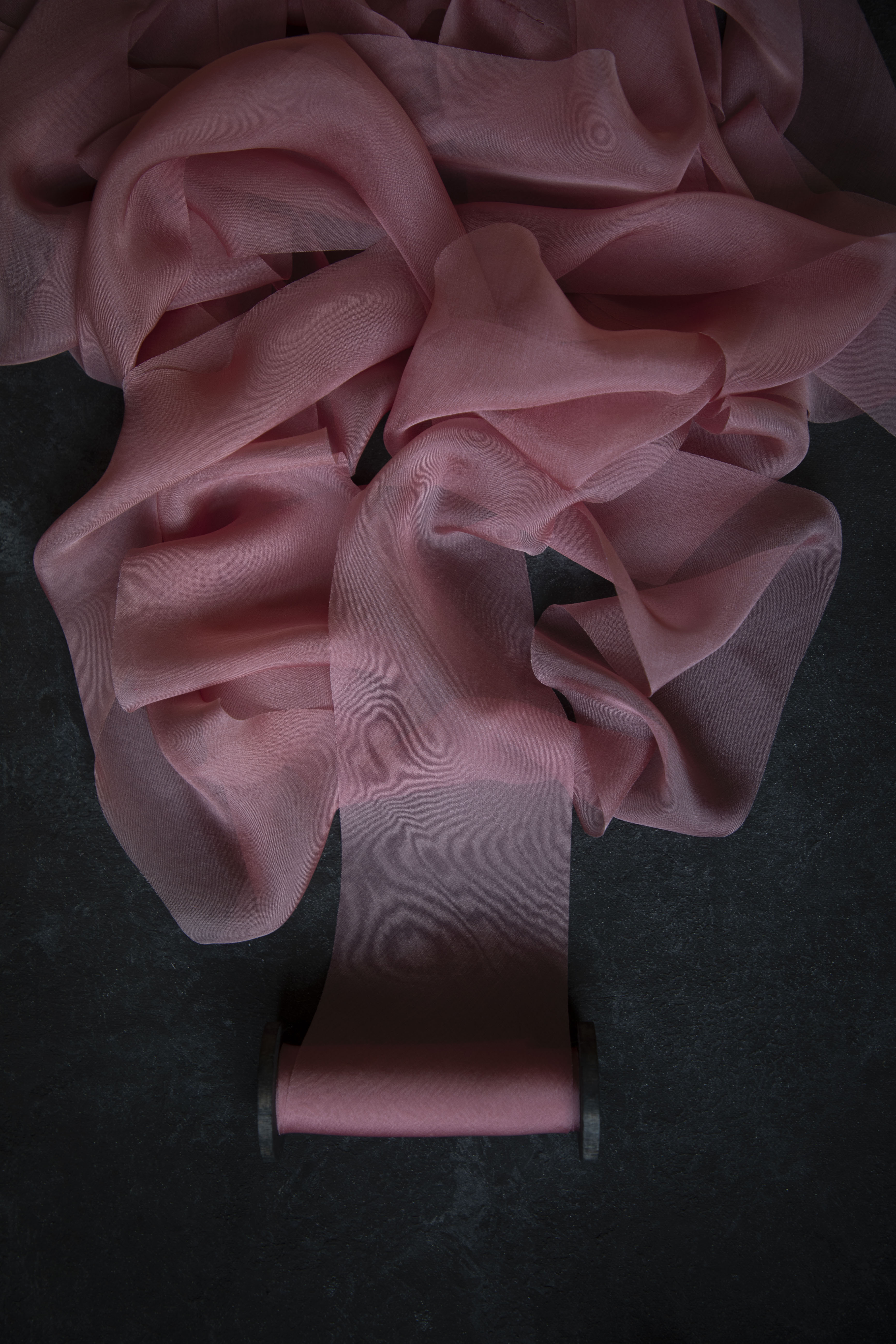 Pink silk ribbon on a dark surface