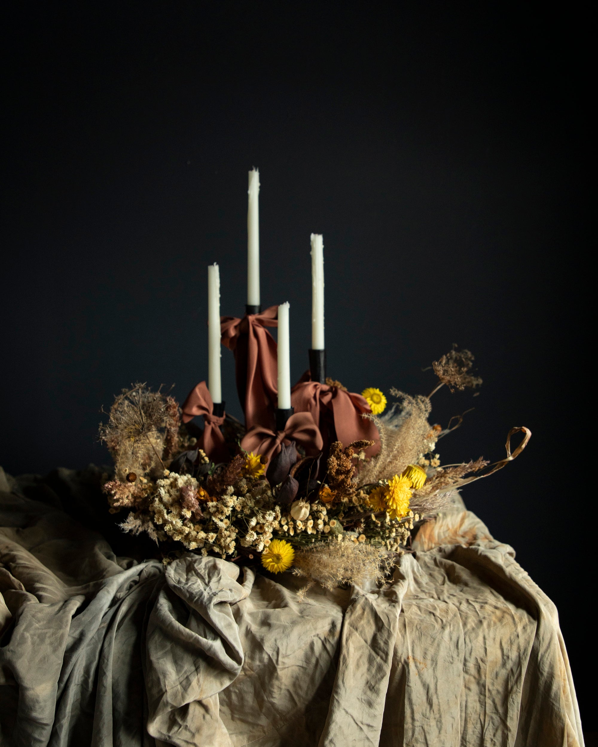 fall harvest centerpiece with dried flowers and candles draping with silk ribbon bows.