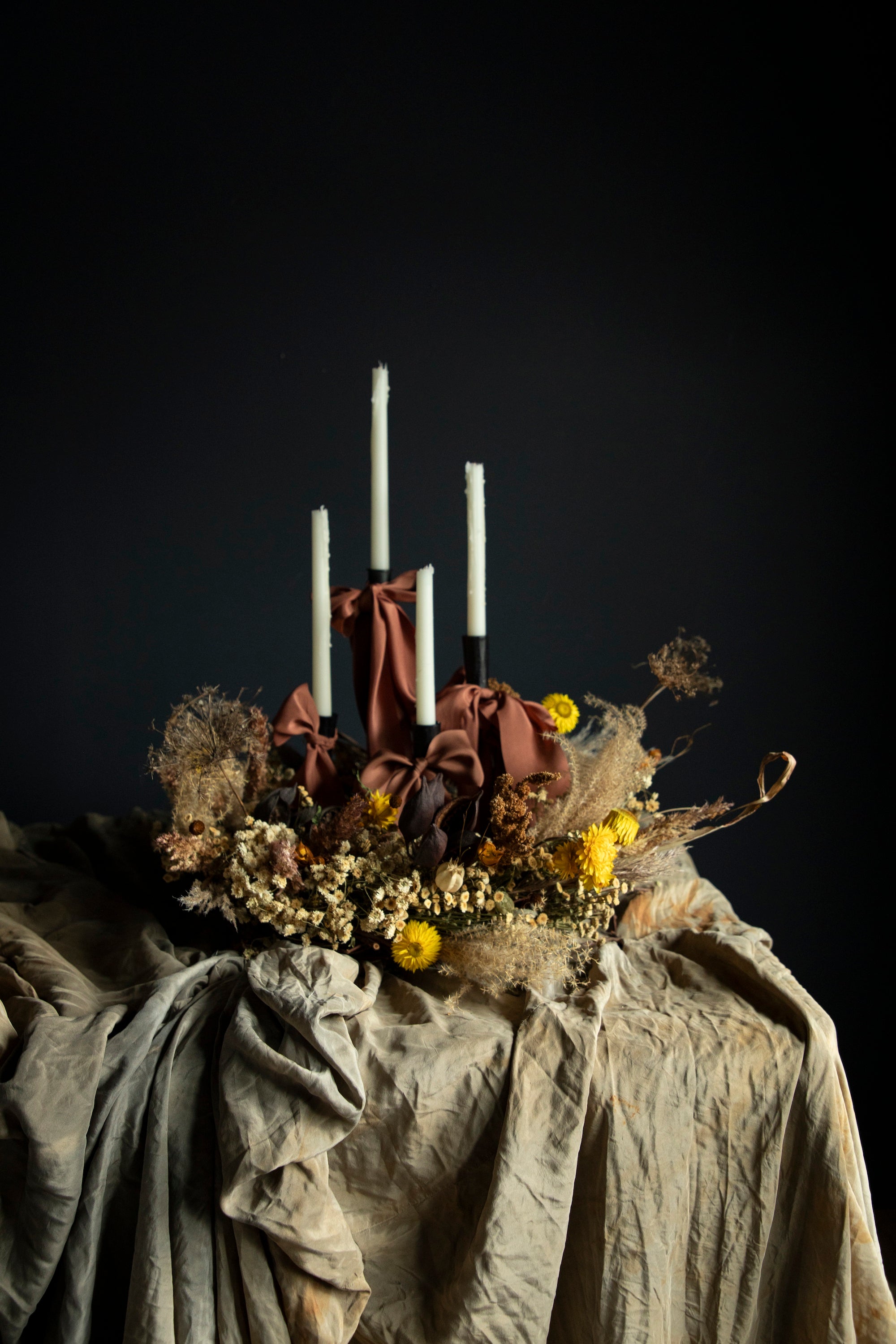 fall harvest centerpiece with dried flowers and candles draping with silk ribbon bows.