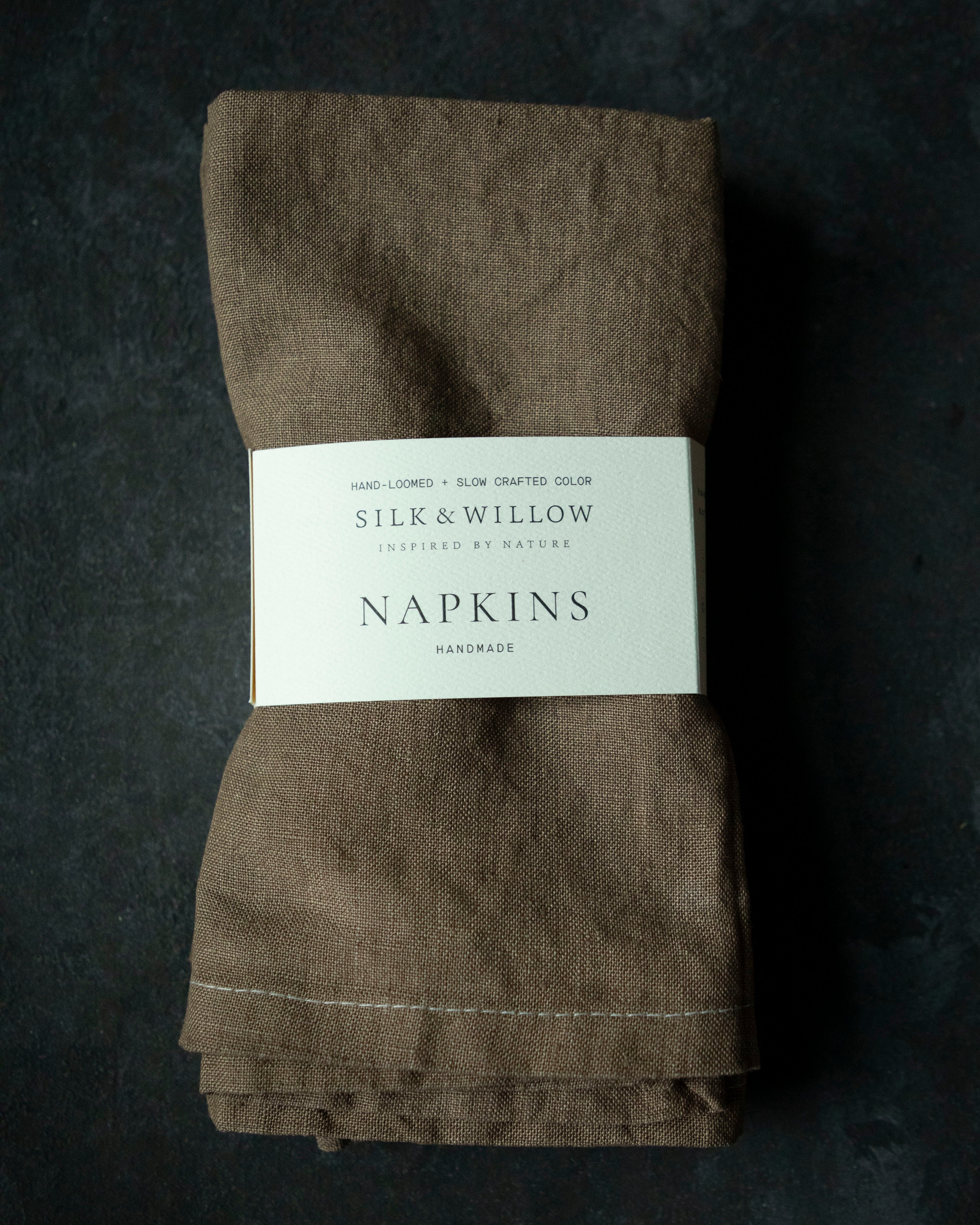 Folded brown napkins with a label on a dark background