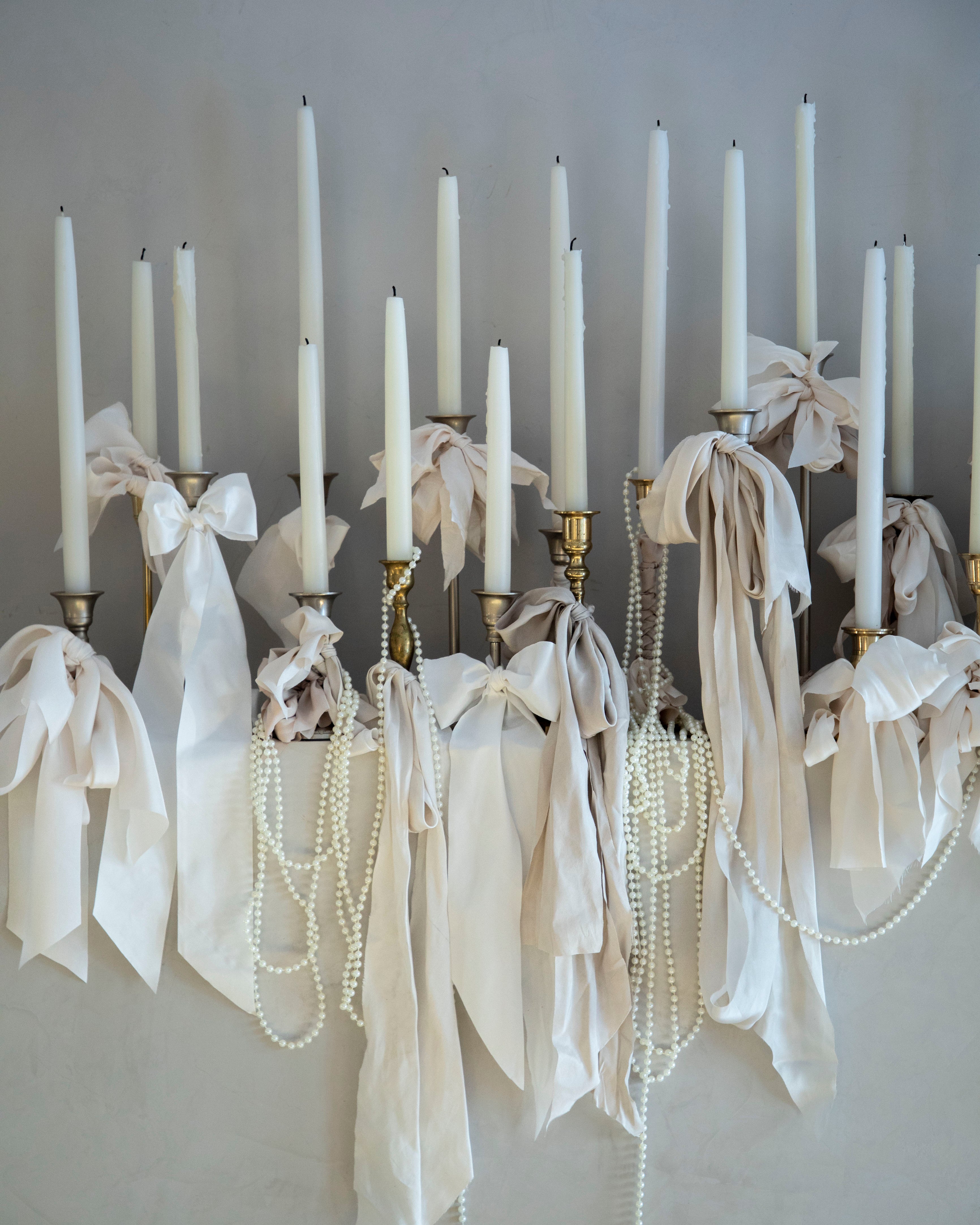 white candles with white ribbon bows wedding decor display