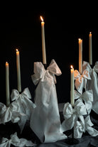 Candles with white ribbons against a black background