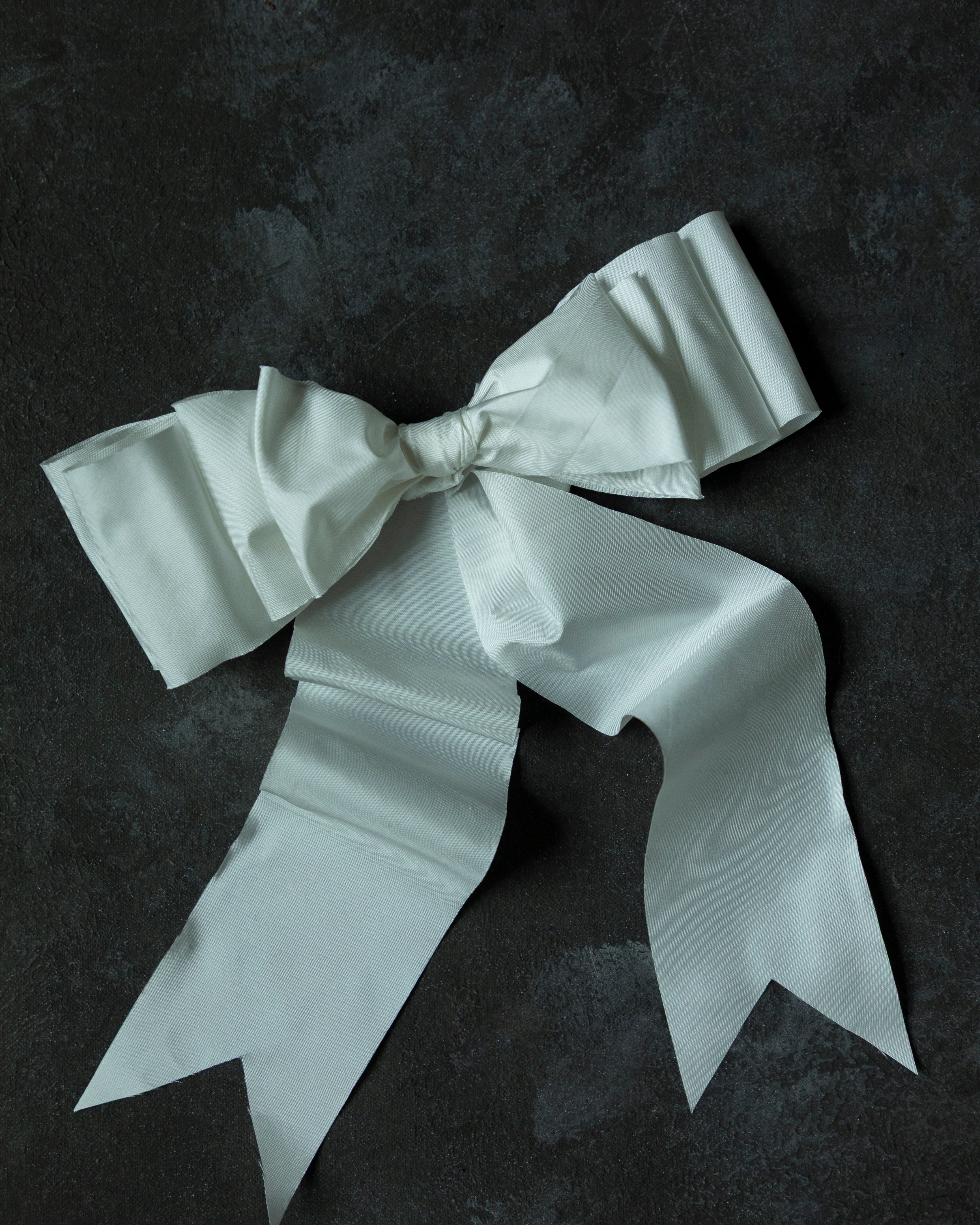 White satin bow on a dark textured background