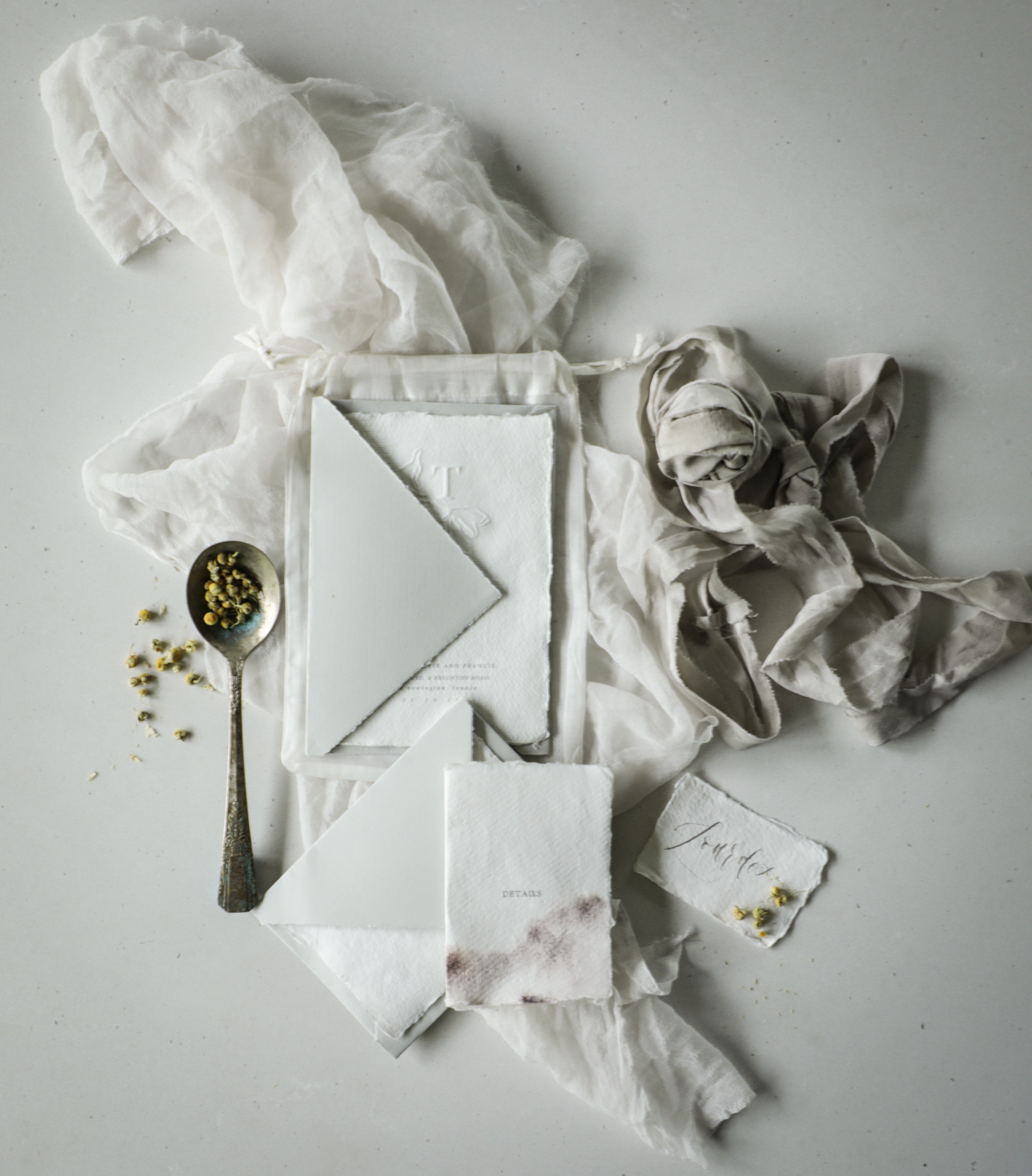 flat lay styling of wedding invitation suite with silk and willow sheer silk, handmade deckled edge paper and arpa envelopes