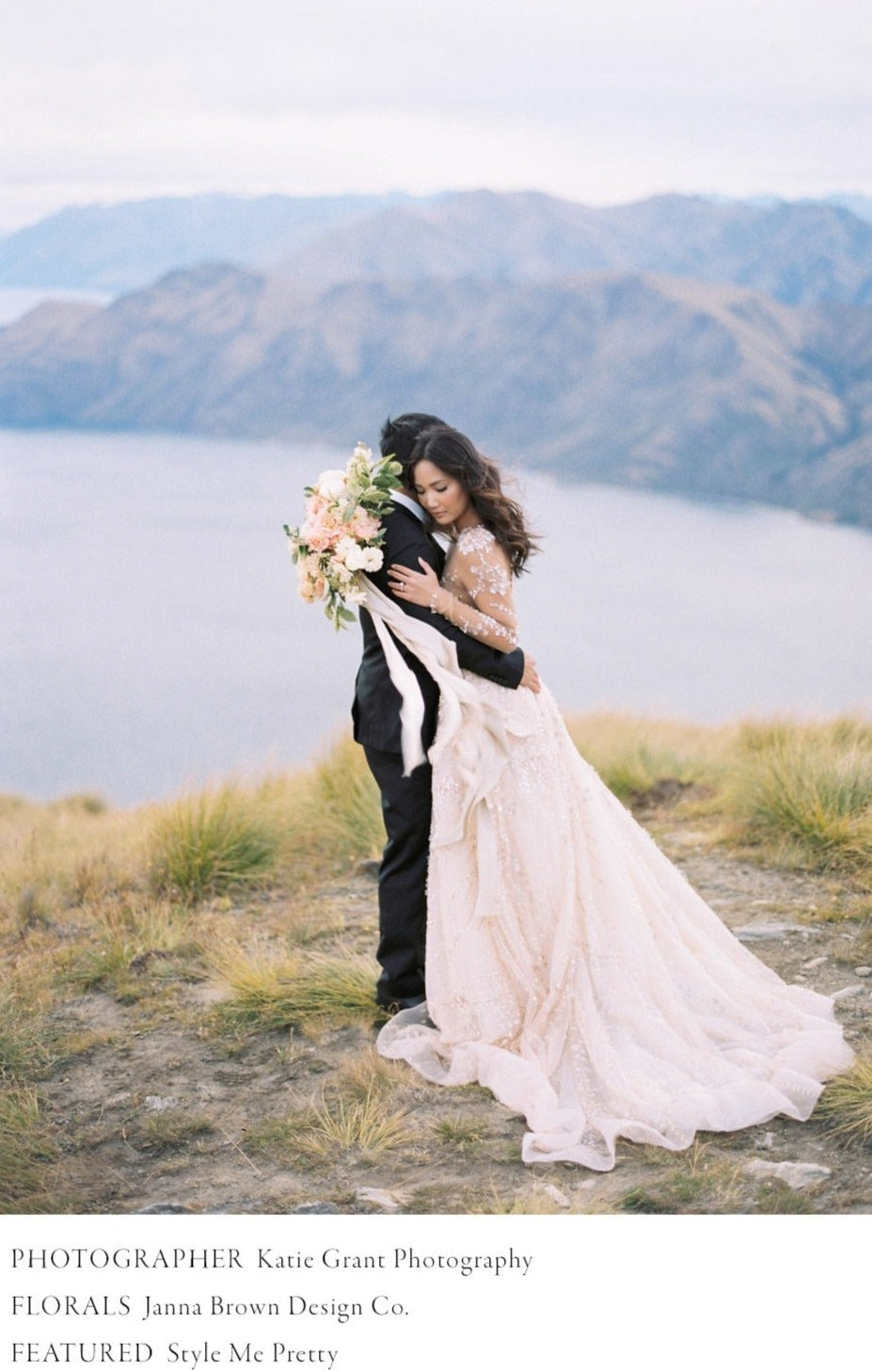bride and groom hugging on New Zealand ridge with bridal bouquet and flowing silk and willow ribbon