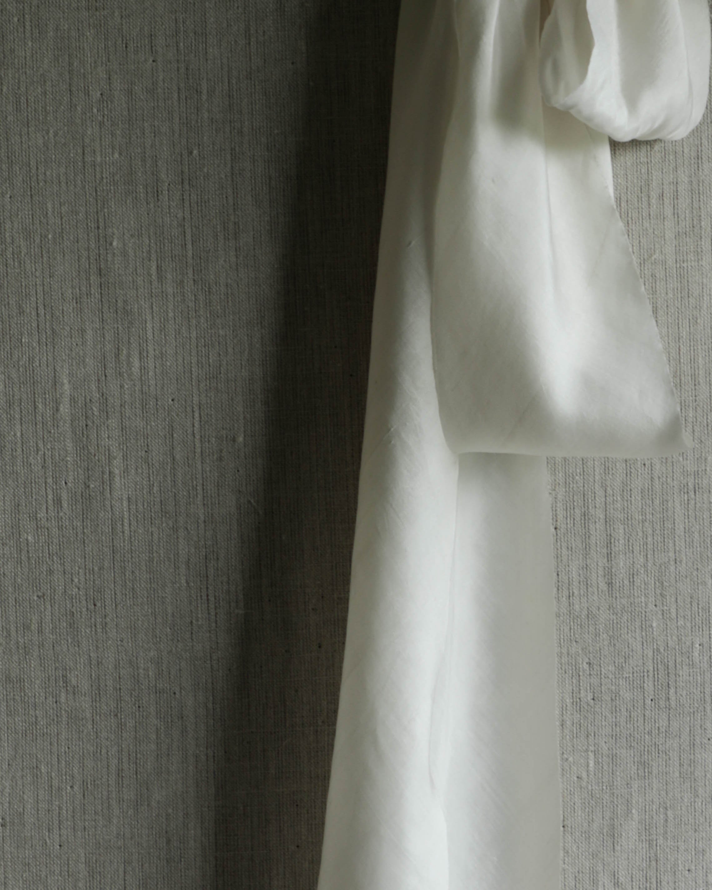 antique white silk ribbon on a linen pin board