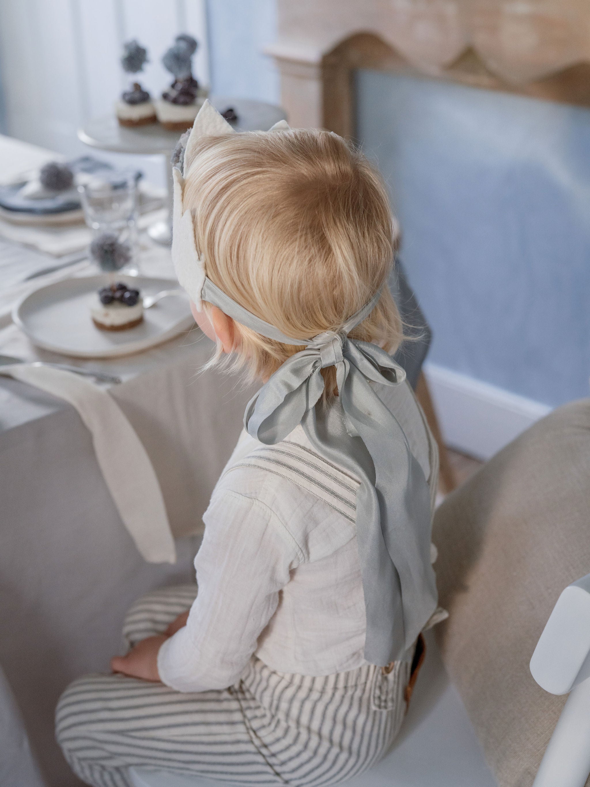 Child sitting at a dining table with a neutral color scheme