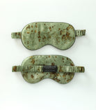 Two green sleep masks with floral patterns on a white background