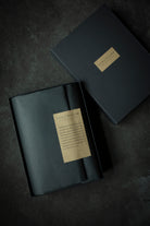 A dark charcoal gray presentation box with a gold label reading 'SILK & WILLOW' and 'The Art of Packaging', shown open with its lid placed beside it on a dark textured background.