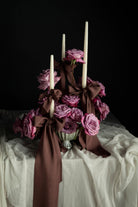 Decorative floral arrangement with candles on a dark background