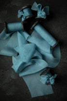 Blue wedding ribbon and spools on a dark surface