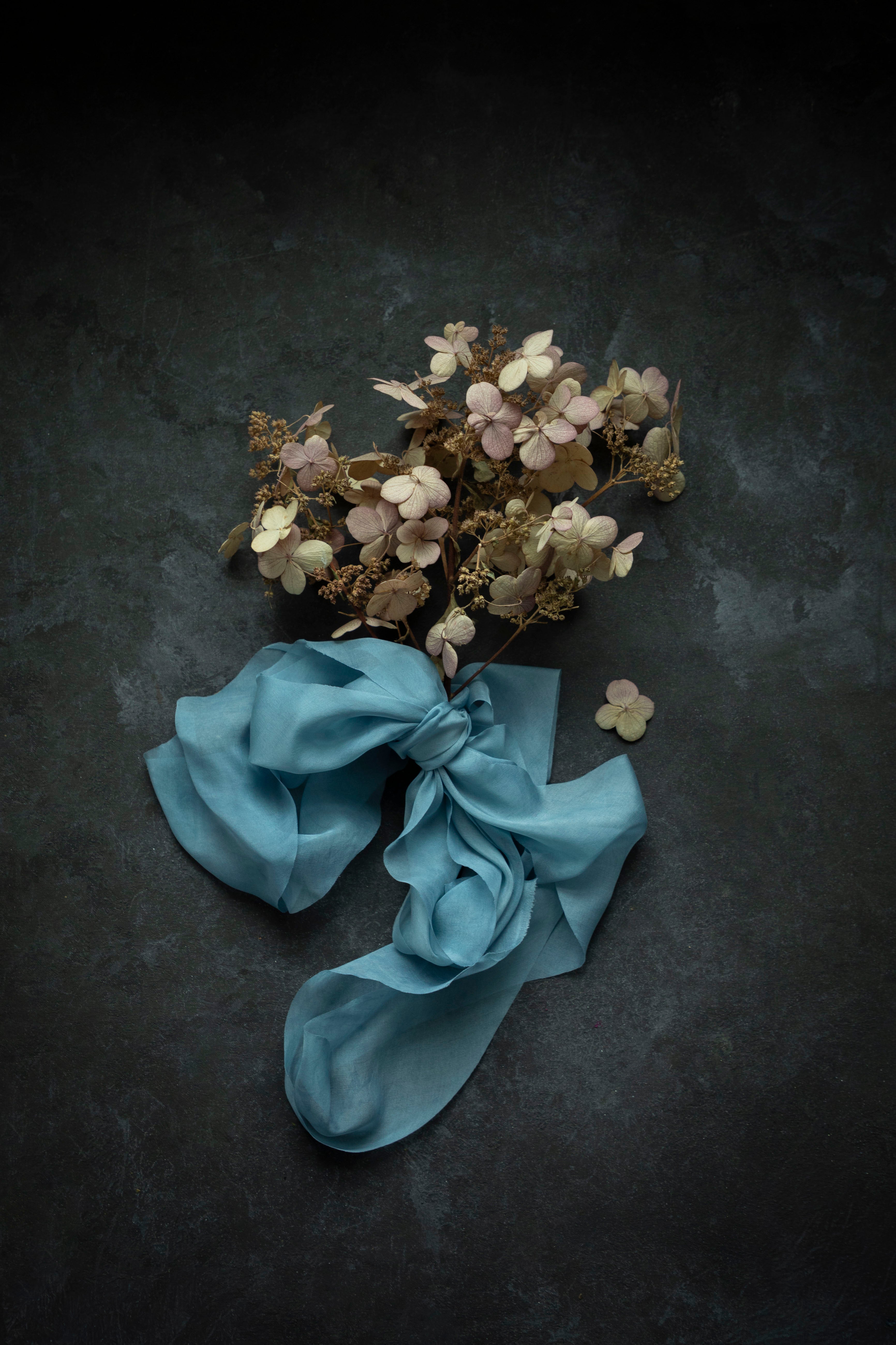 Dried flowers tied with a blue ribbon on a dark background