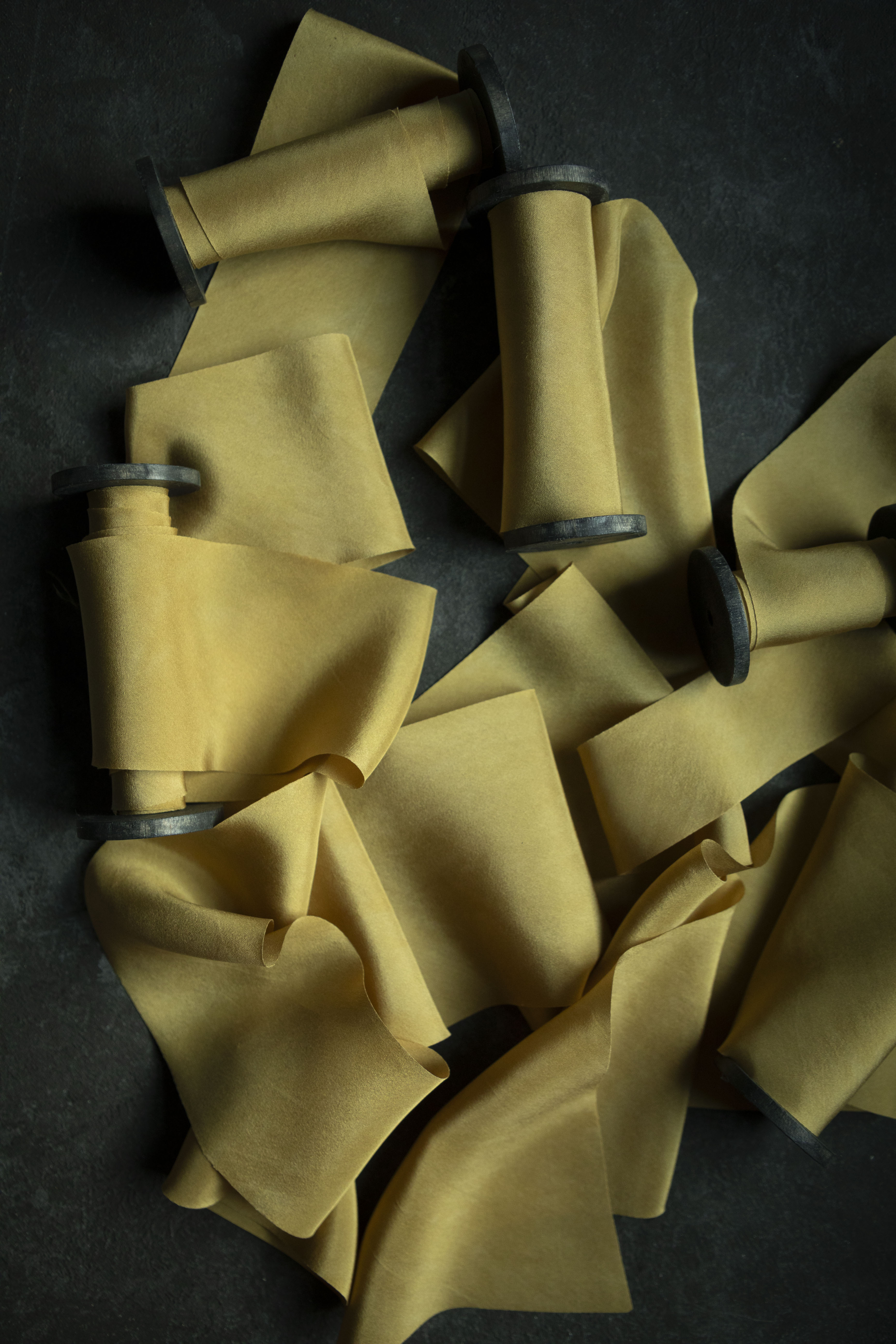 Yellow ribbon with on black spools on a dark surface