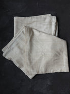 Folded light gray fabric on a dark surface
