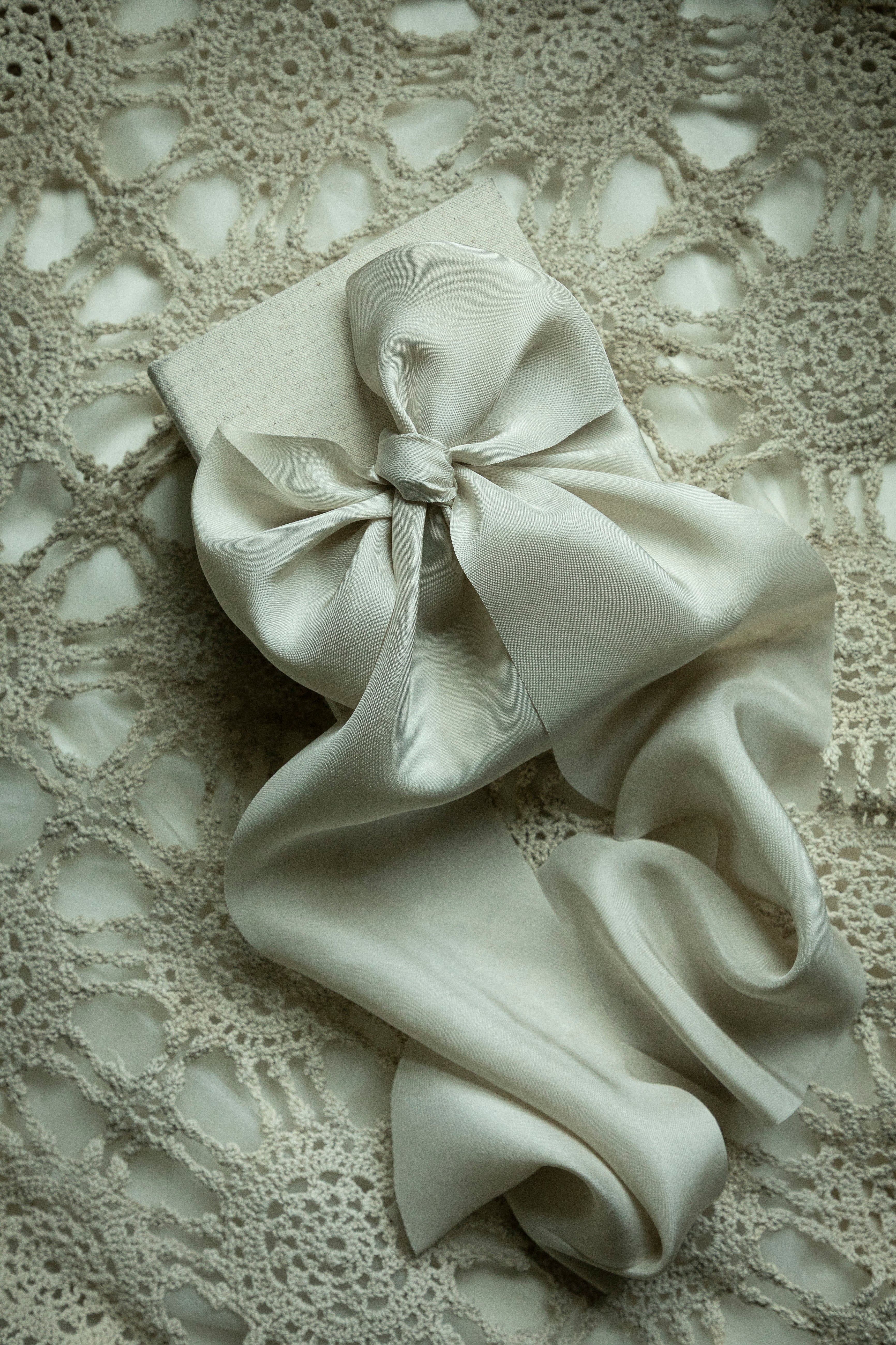 White bow on a textured beige background