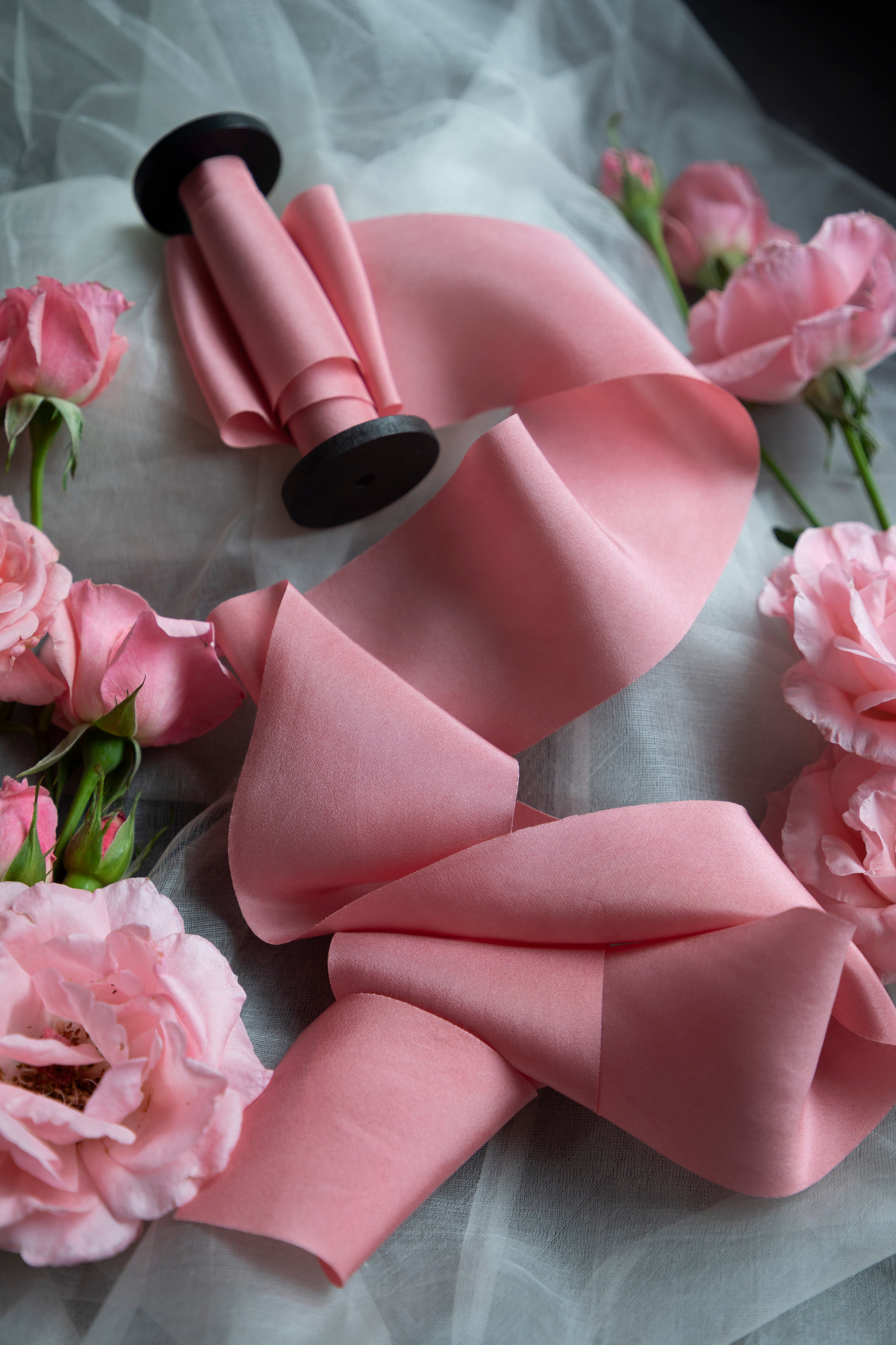 Pink bow with black centers on a gray background with pink flowers