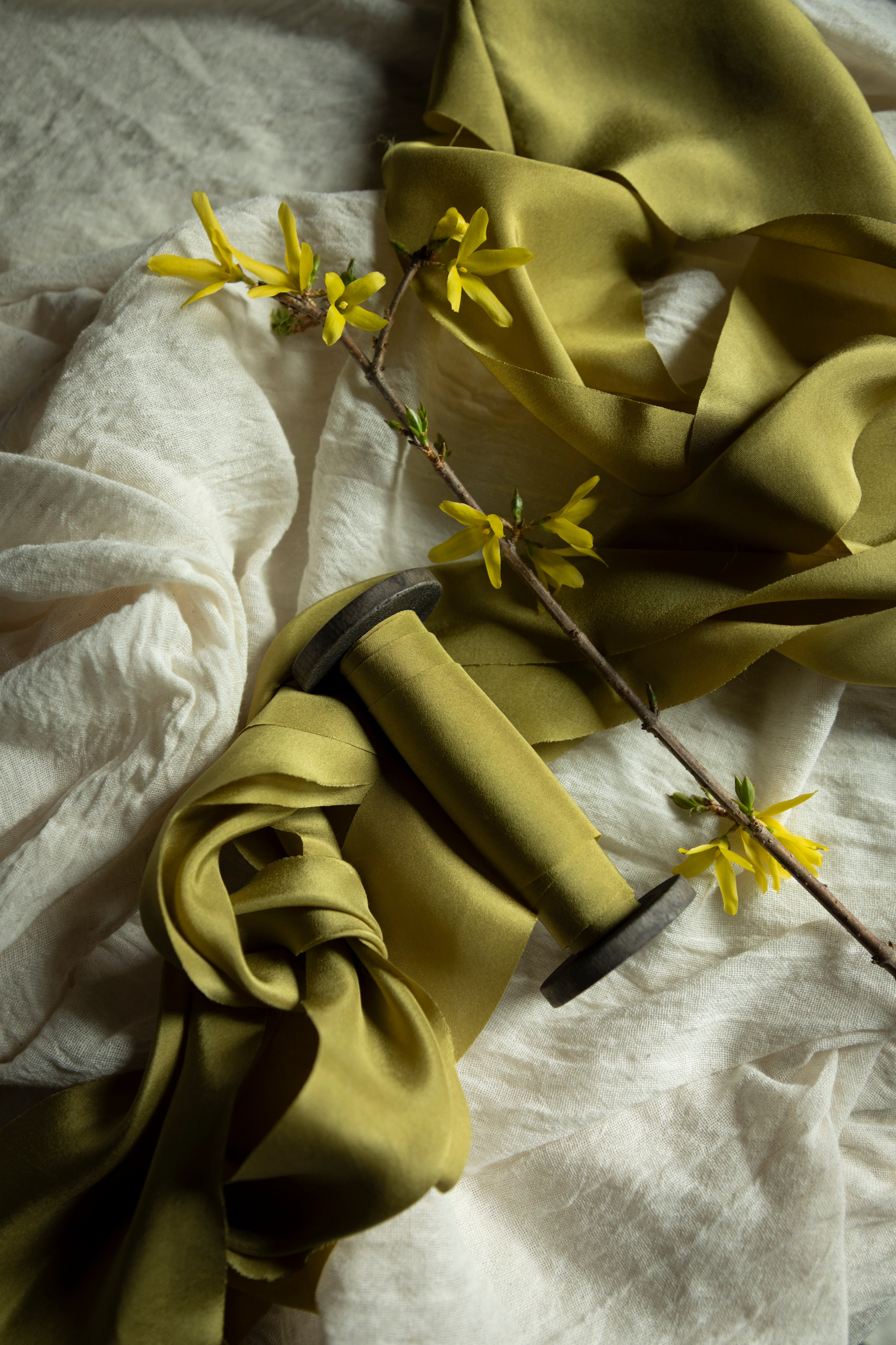 chartreuse ribbon with yellow flowers on a textured surface