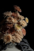 Bouquet of dried flowers in a glass vase on a dark background