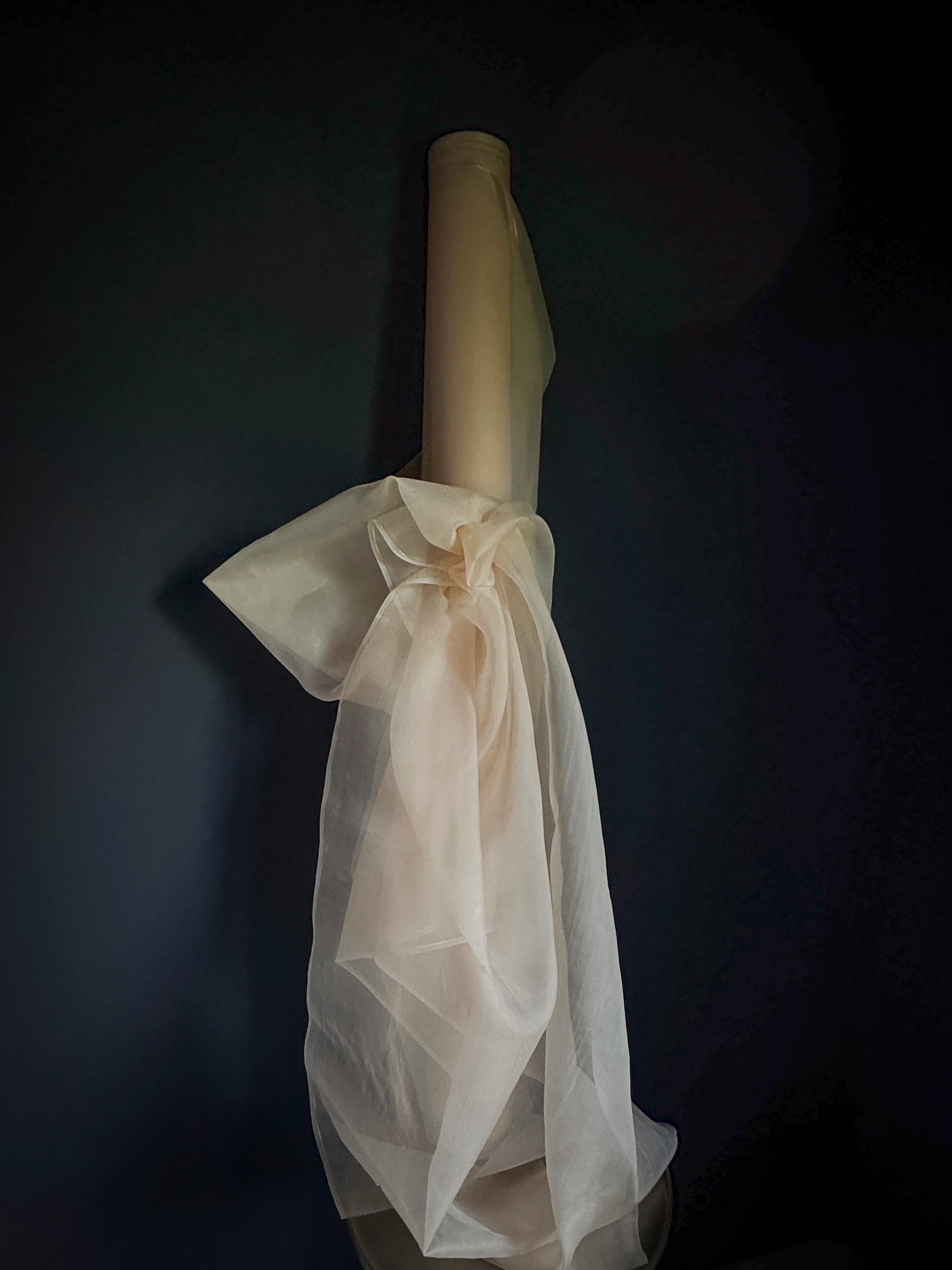 Roll of silk organza pink fabric against a dark background