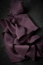 Purple ribbon draped over a dark surface