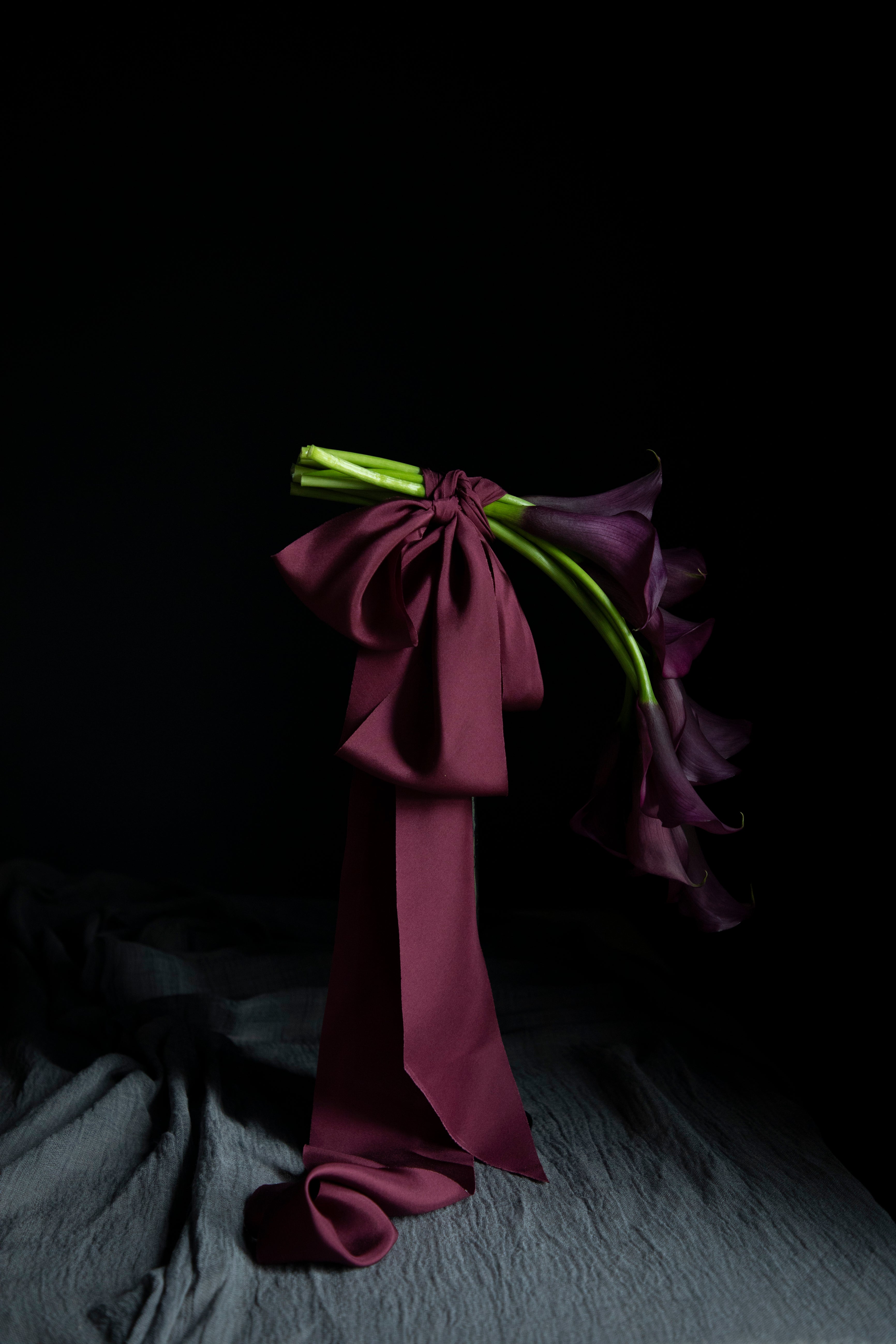 floating purple calla lily flowers tied with purple ribbon bows